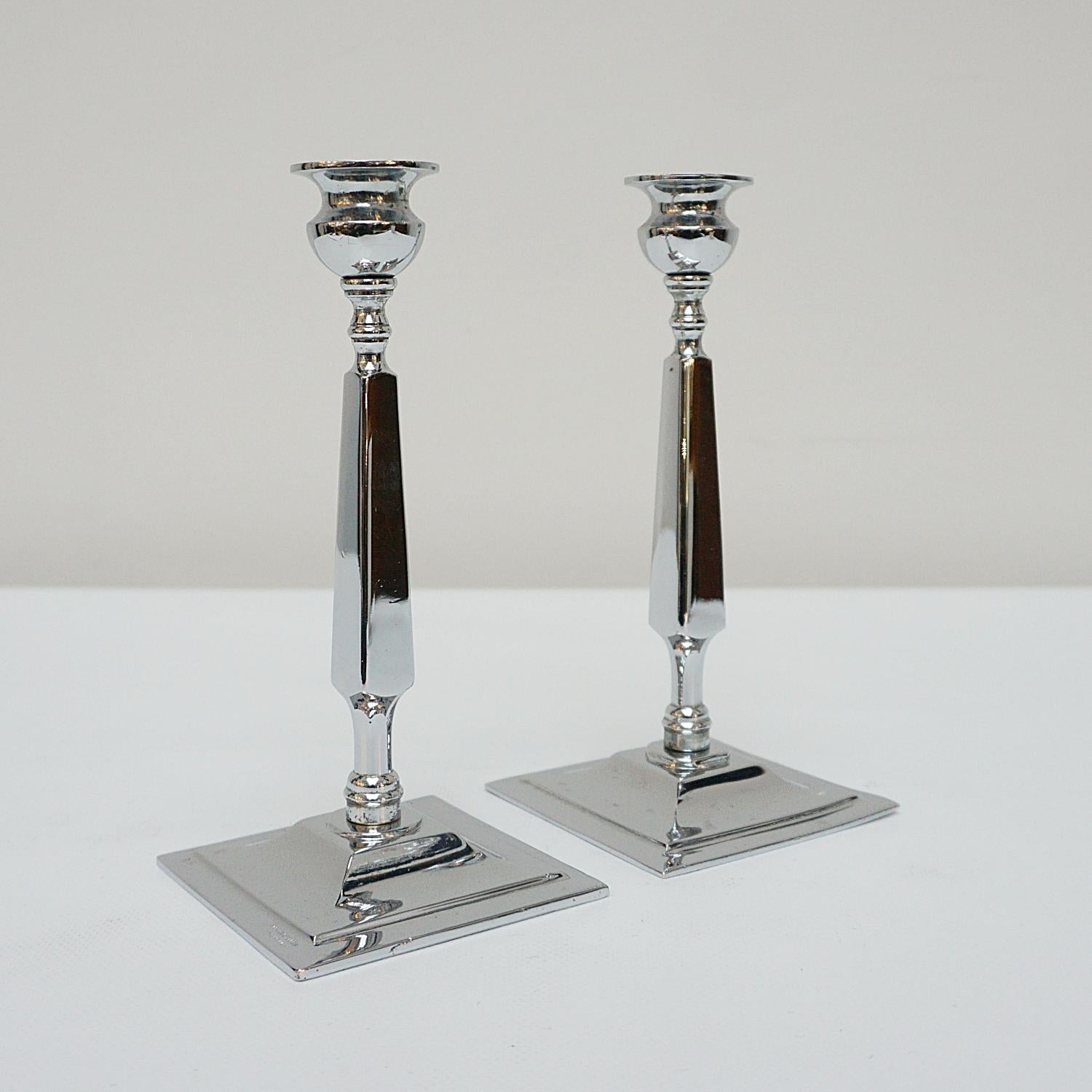 A pair of Art Deco candlesticks. Chromed squared stem. Set over a square, stepped chromed metal base with chromed metal top. 

Dimensions: H 20cm W 9cm

Origin: English

Date: Circa 1935

Item Number: 2710237

Re-chromed and polished with some