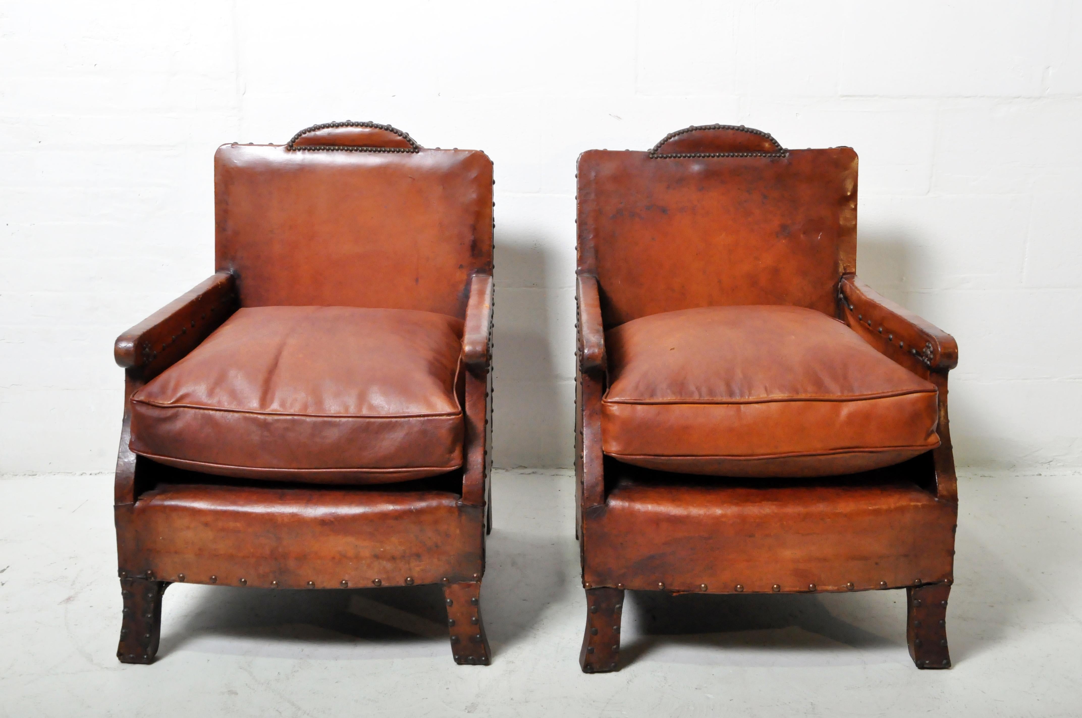 Une paire exceptionnelle de petits fauteuils club en cuir Art Deco français vintage. Le cuir est en bon état avec une excellente patine et seulement des égratignures attendues et modestes, des déchirures réparées et d'autres imperfections de l'âge.