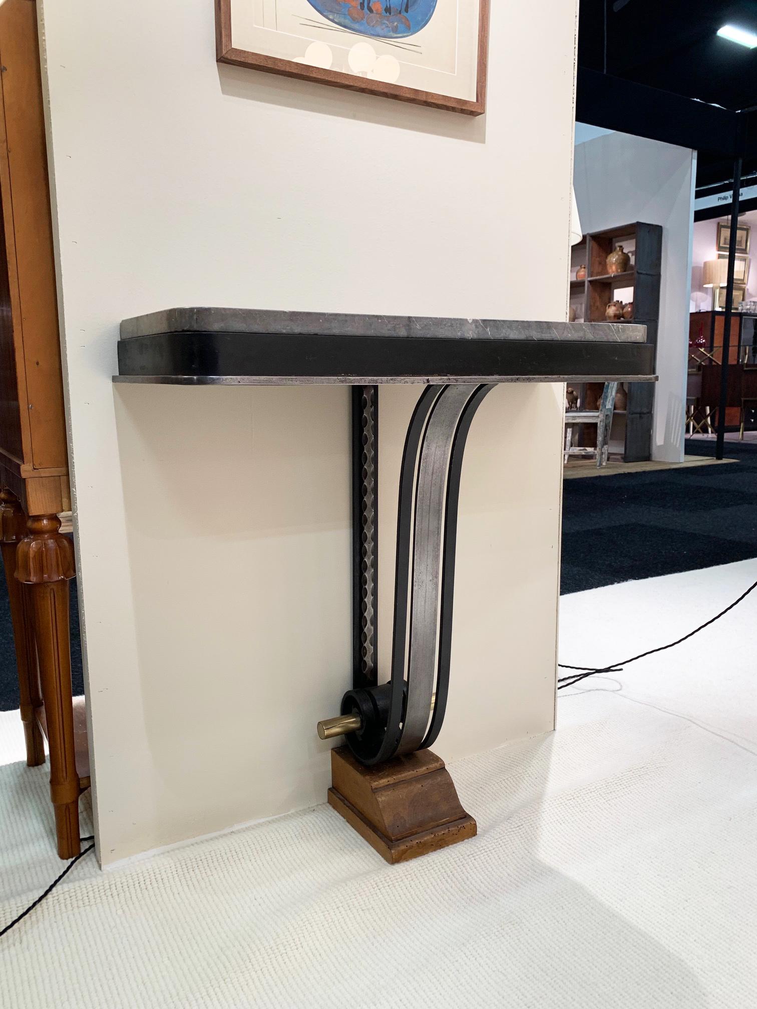 A pair of Art Deco console tables
the steel, brass and black enameled iron scrolling bodies supporting shaped Saint Anne marble tops, resting on a moulded walnut bases.
France, circa 1930.