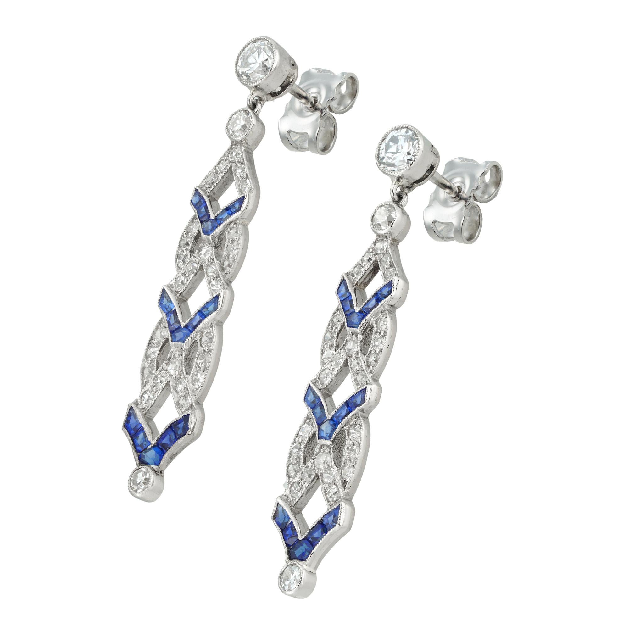 A pair of Art Deco diamond and synthetic sapphire drop earrings, each earring with an old brilliant-cut diamond top estimated to weigh 0.2 carats, millegrain-set to platinum collet, suspending an openwork plaque of geometric design, set with old
