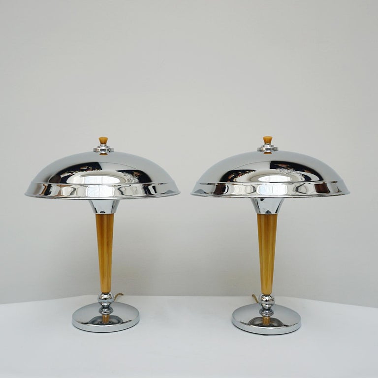 A Pair of Art Deco style dome lamps. Fluted tube of marbled yellow bakelite stem, set over a chromed metal base. Yellow finial topped chromed metal shade. 

Dimensions: H 44cm Diameter of shade: 35cm, of base: 16cm

All of our lighting is fully