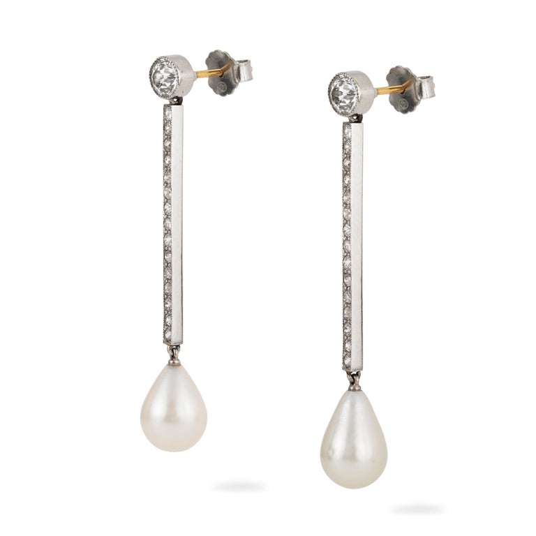 A pair of Art Deco natural pearl and diamond drop earrings, the drop shape natural saltwater pearls weighing 8.47 carats together, accompanied by Gem & Pearl Laboratory report , each suspended from a run of millegrain channel-set old brilliant-cut