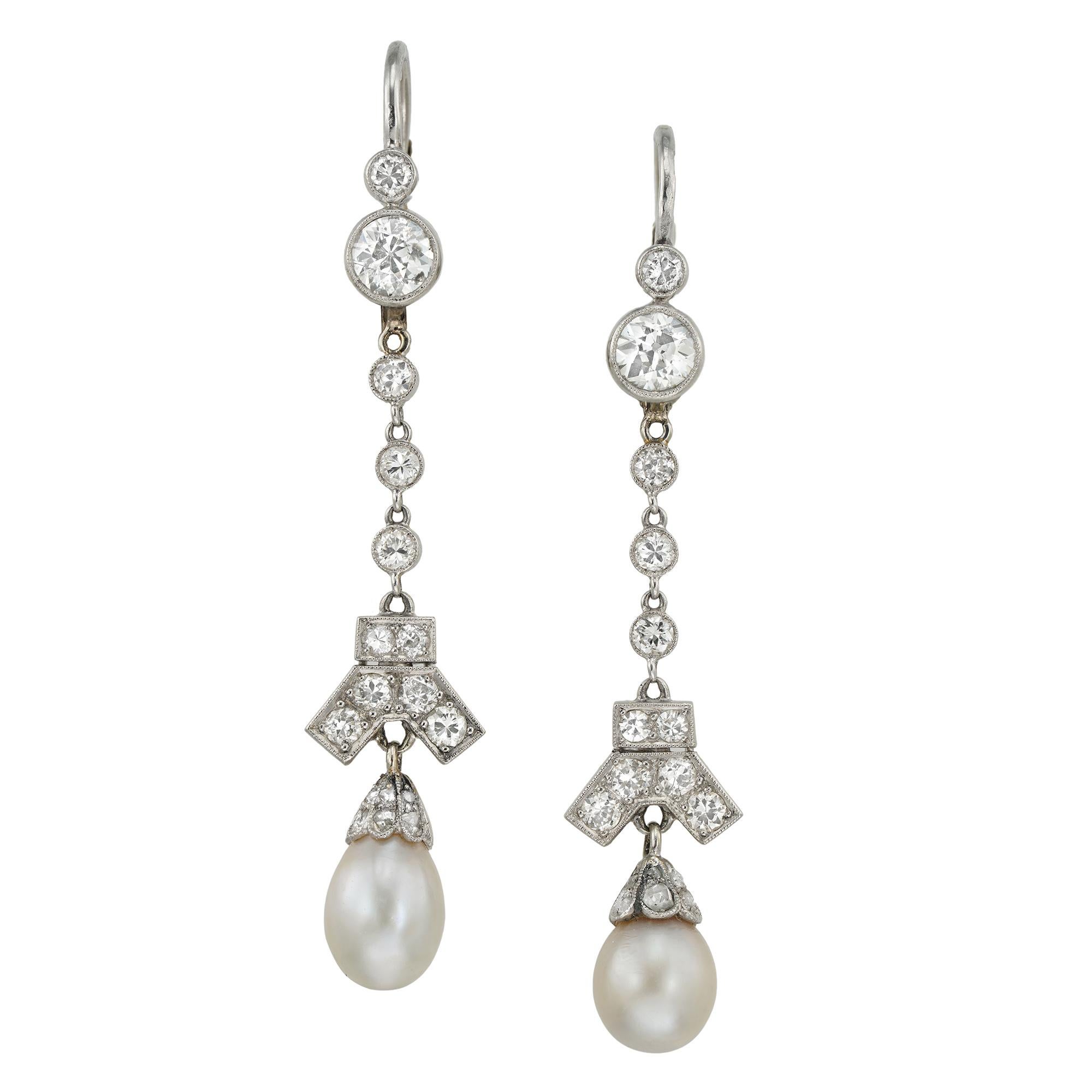A pair of Art Deco natural pearl and diamond drop earrings, each consisting of two old brilliant-cut diamond-set top, suspending a line of three smaller old-brilliant-cut diamonds, with a Y-shaped diamond-set decoration terminating to a natural
