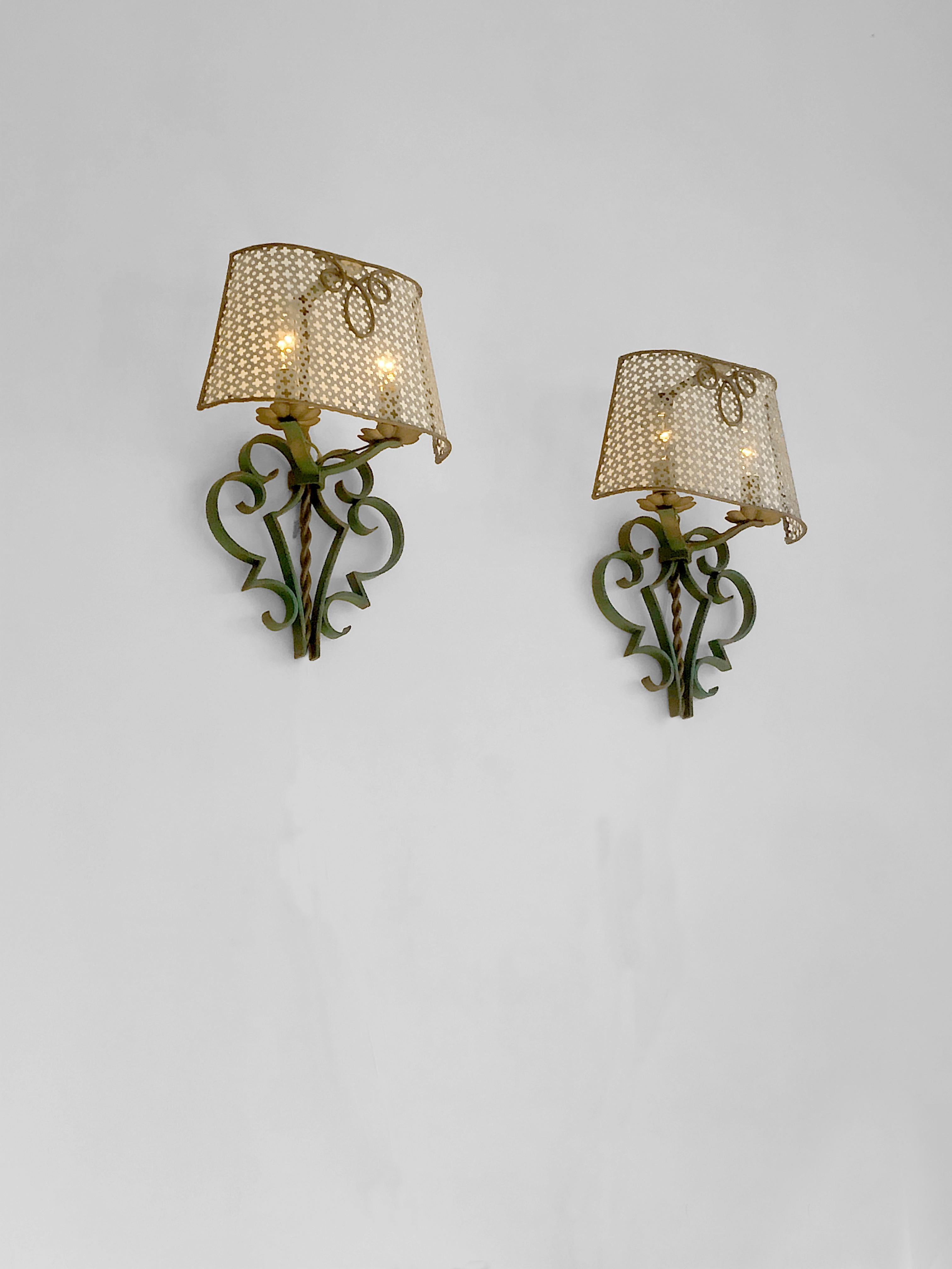 A beautiful and highly decorative pair of wall sconces, in the spirit of the early creations by Mathieu Mategot, France, 1940-1950.
Each sconce is based on a neoclassical painted iron base, remembering the  stylish art-deco iron works of Raymond