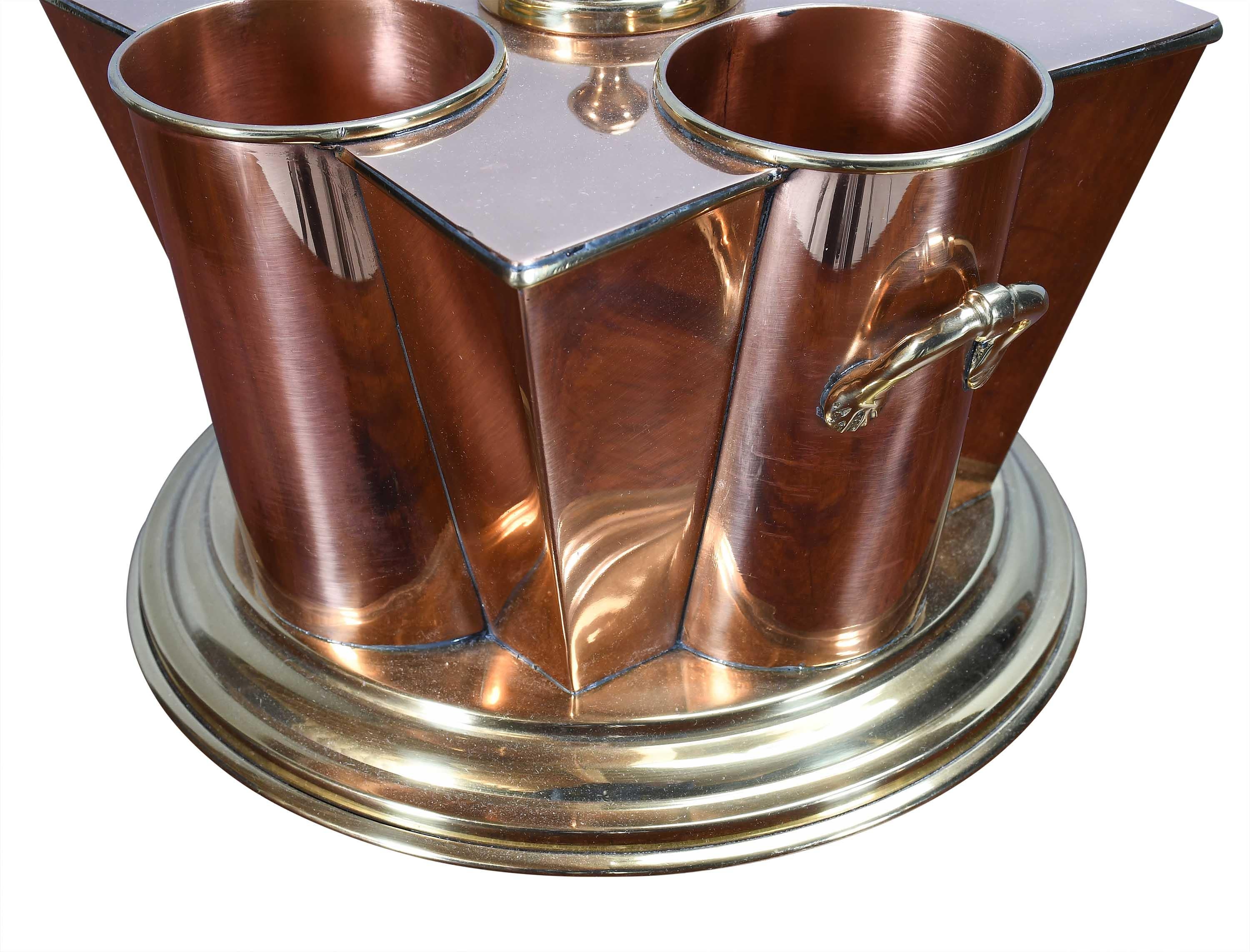 Ein schönes Paar Weinkühler aus Kupfer und Messing aus der Zeit des Art Déco, die auf dem Tisch stehen. Jeder hat vier zylindrische Vertiefungen, die jeweils für eine einzelne Flasche ausgelegt sind. Jede Vertiefung ist um die Seiten eines sich