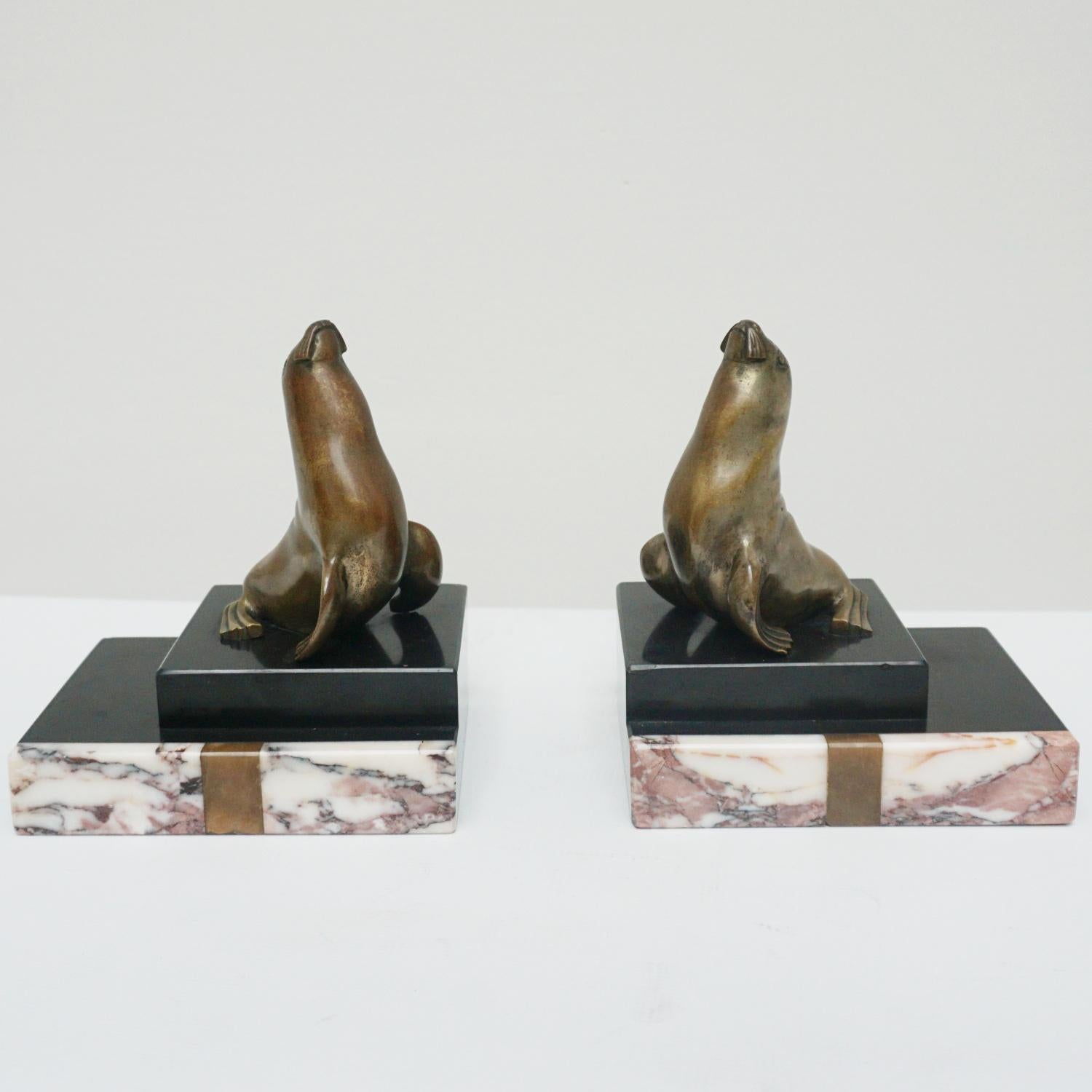 A pair of Art Deco bookends. Bronze sea lions set over a black marble base with front patterned marble edge. 

Dimensions: H 17cm W 15cm D 11cm.

Origin: French.

Date: circa 1930.

Item number: 2405229.