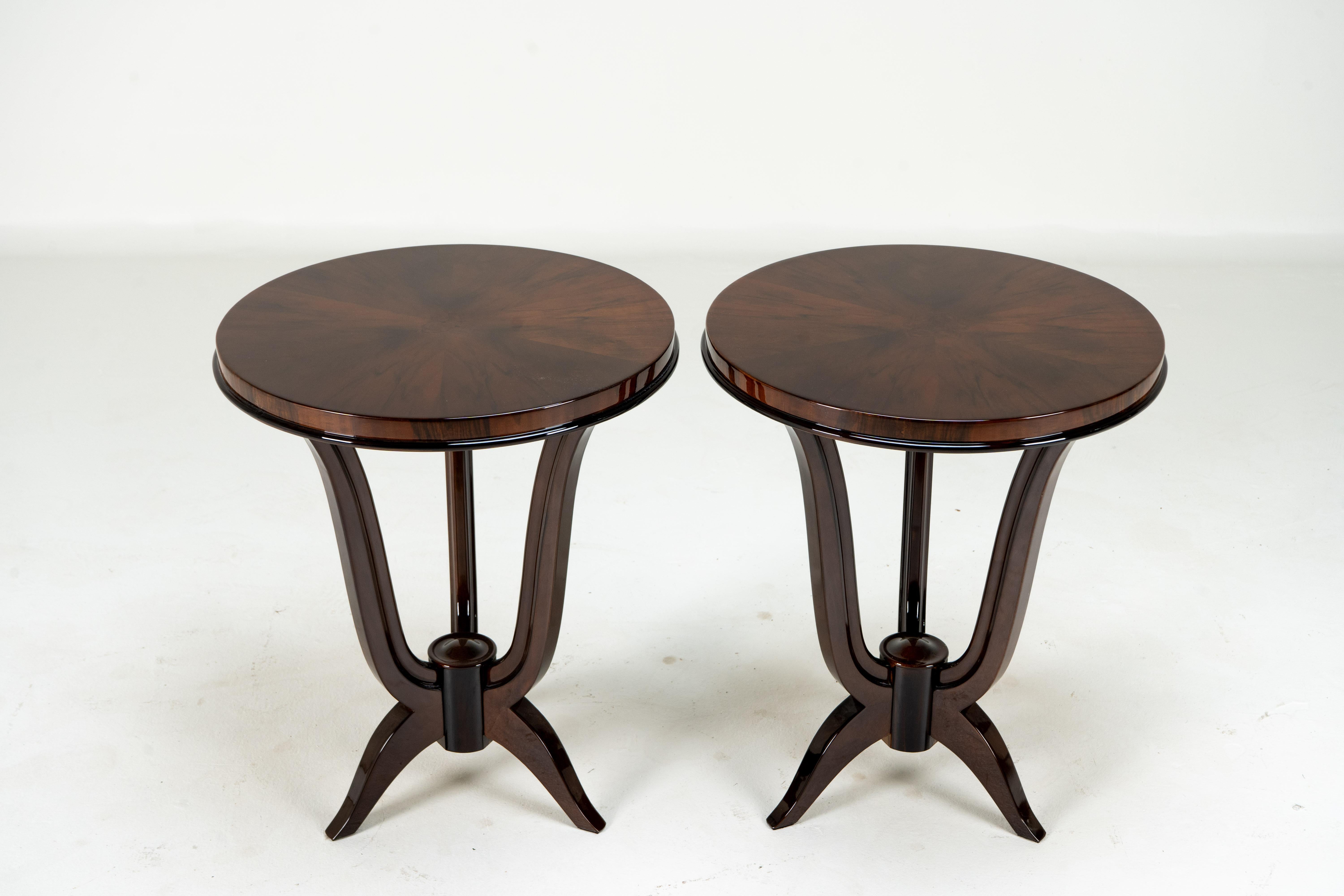A very elegant and curvaceous side table in the high French Art Deco style. This round side table is highly polished and carries a dark lacquer coating over the walnut veneer. Price for Pair.

