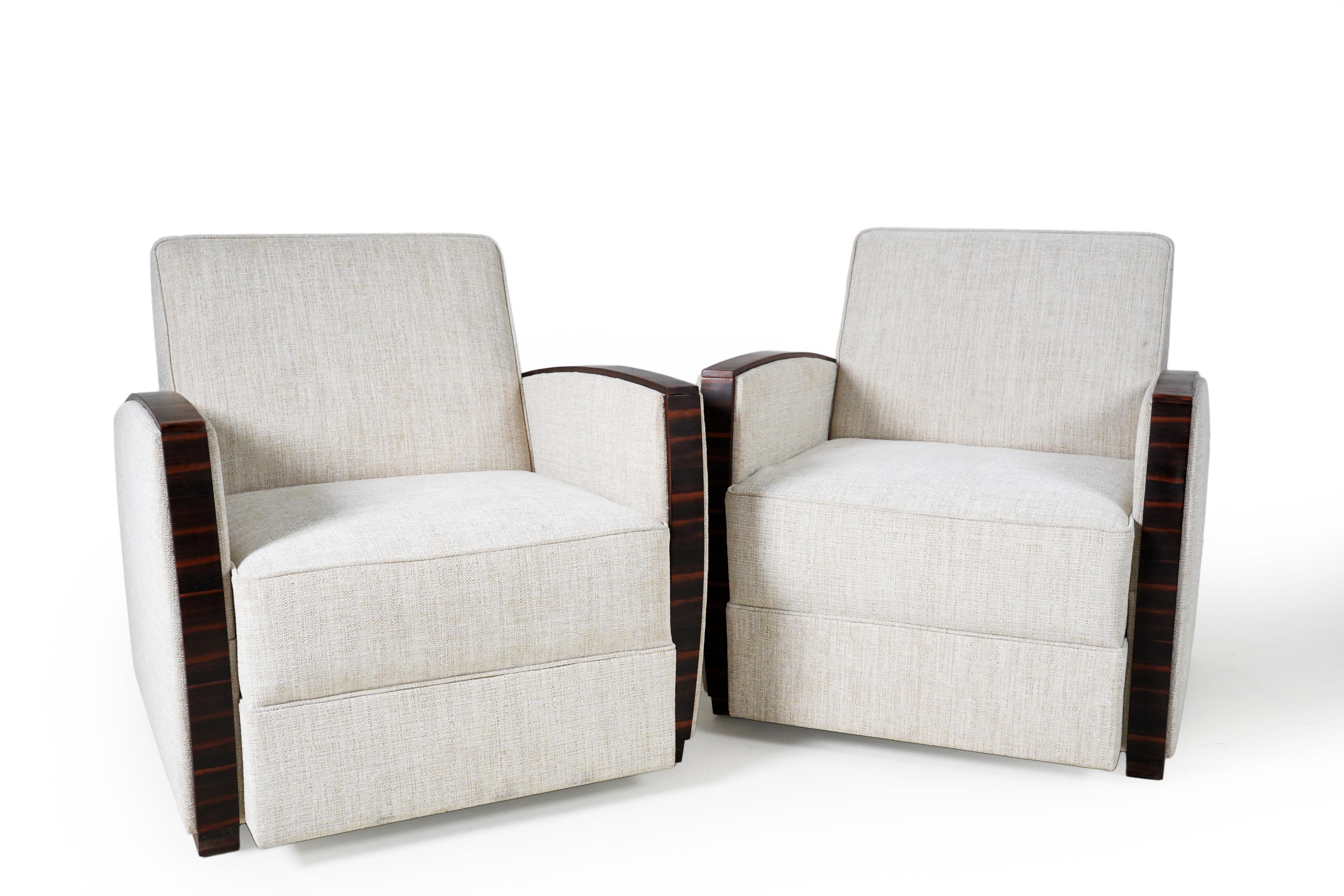These sculptural and softly voluminous armchairs are modern copies of 1930's Hungarian originals. The rich walnut veneer provides a sleek accent to the plush upholstered seats and exterior surfaces. These chairs are comfortable and substantial