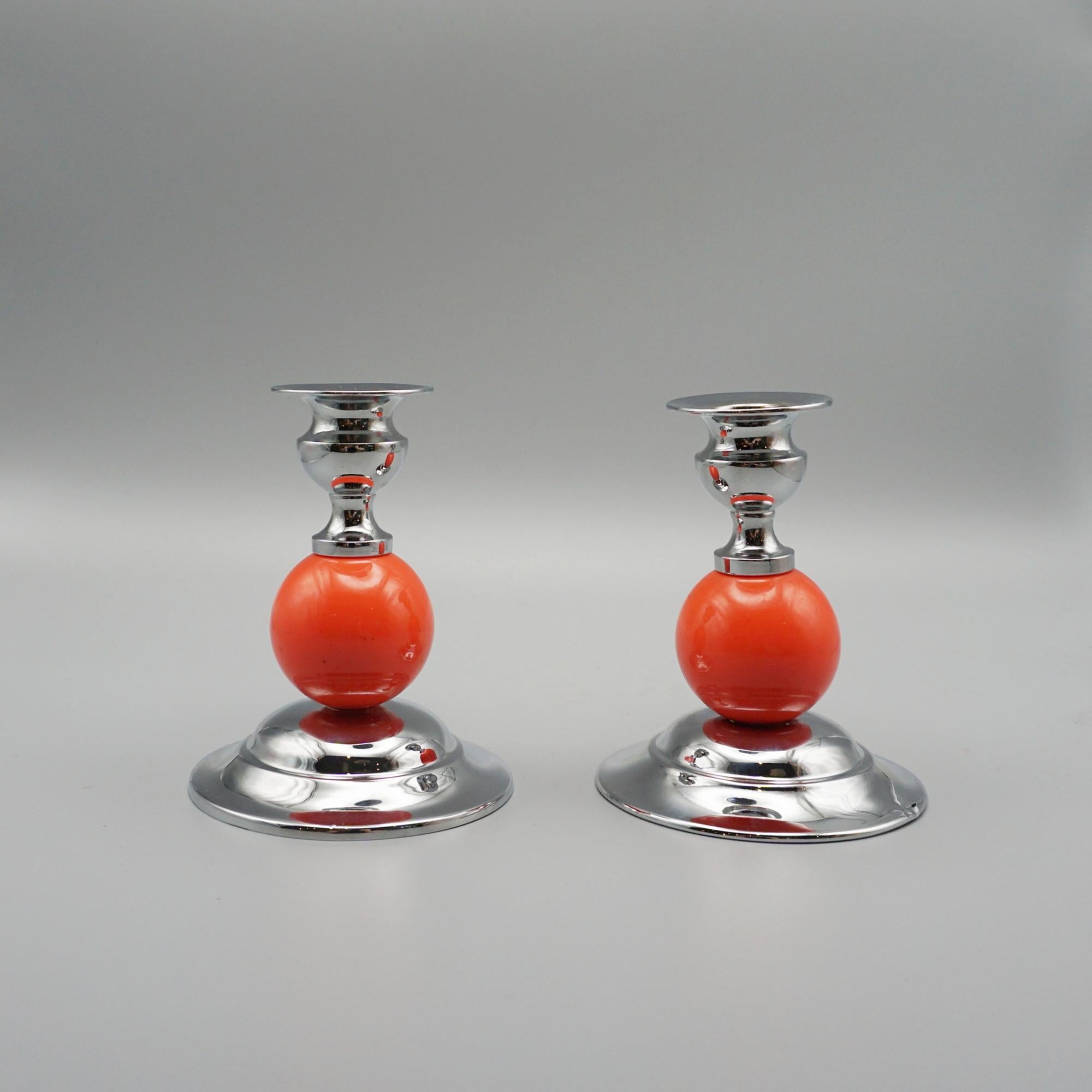 A Pair of Art Deco style candlesticks. Chromed metal candle holder and circular stepped base with a light orange bakelite stem. 