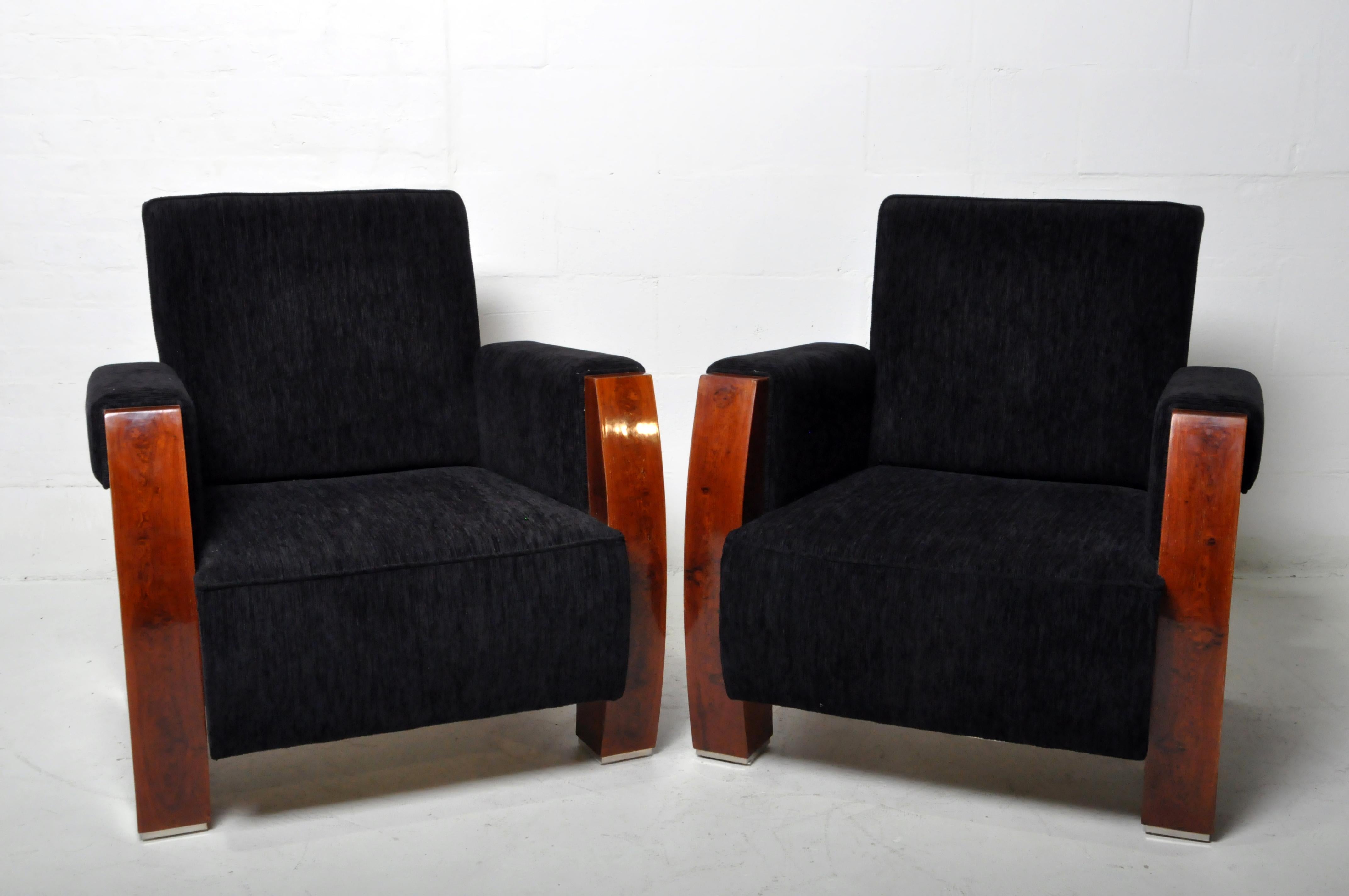 A pair of Hungarian Mid-Century style arm chairs with walnut veneer and chenille upholstery. Hungarian furniture makers have been exceptionally skilled with wood veneers since the Biedermeier era. These stylish chairs date to the 1950's and draw on