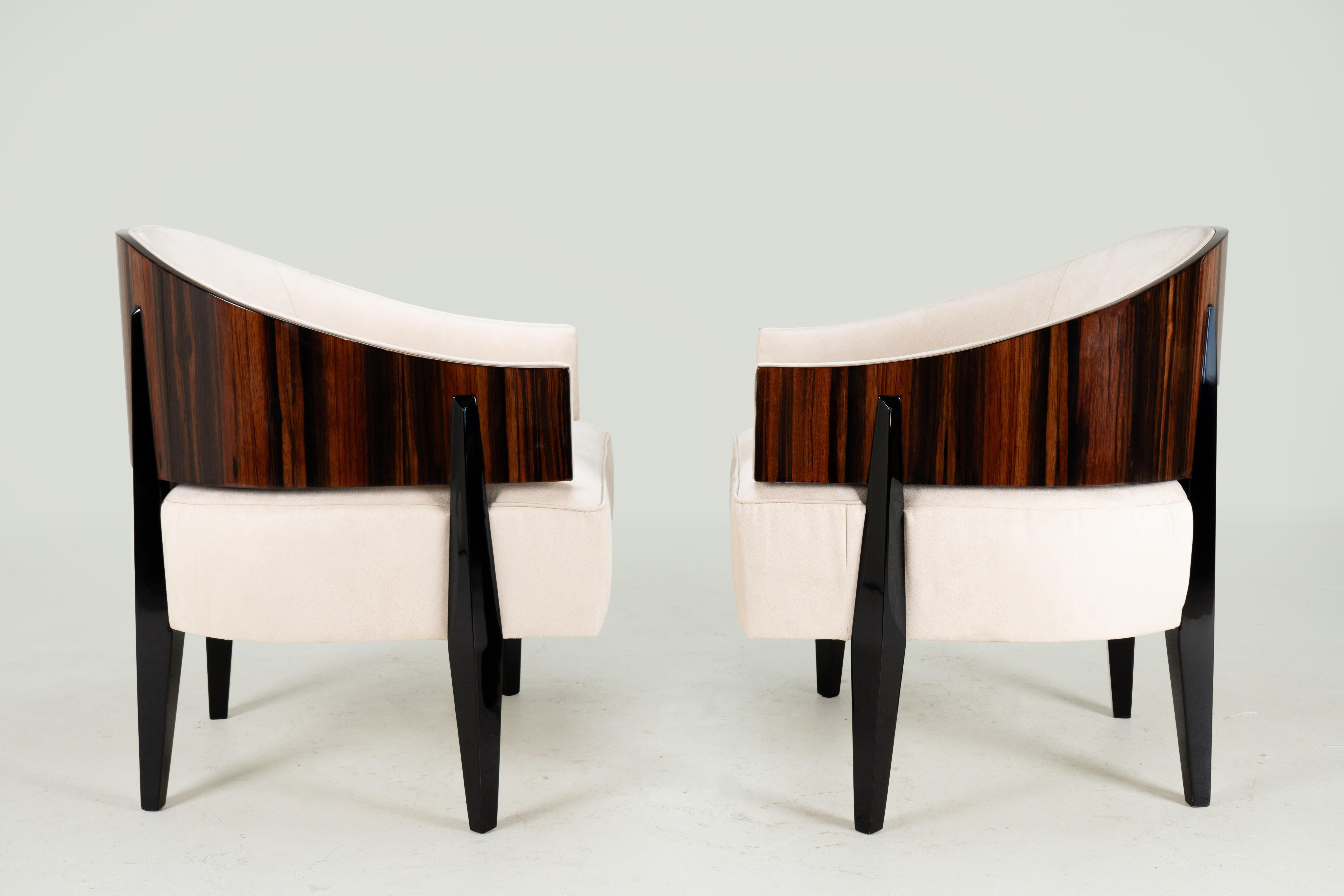 This pair of Hungarian armchairs was produced in 1960’s Budapest in the manner of French Art Deco. The stylishly curved yoke-shaped backs are finished in high-polish macassar veneer. The legs are carved from solid walnuts, with a very dark stain.