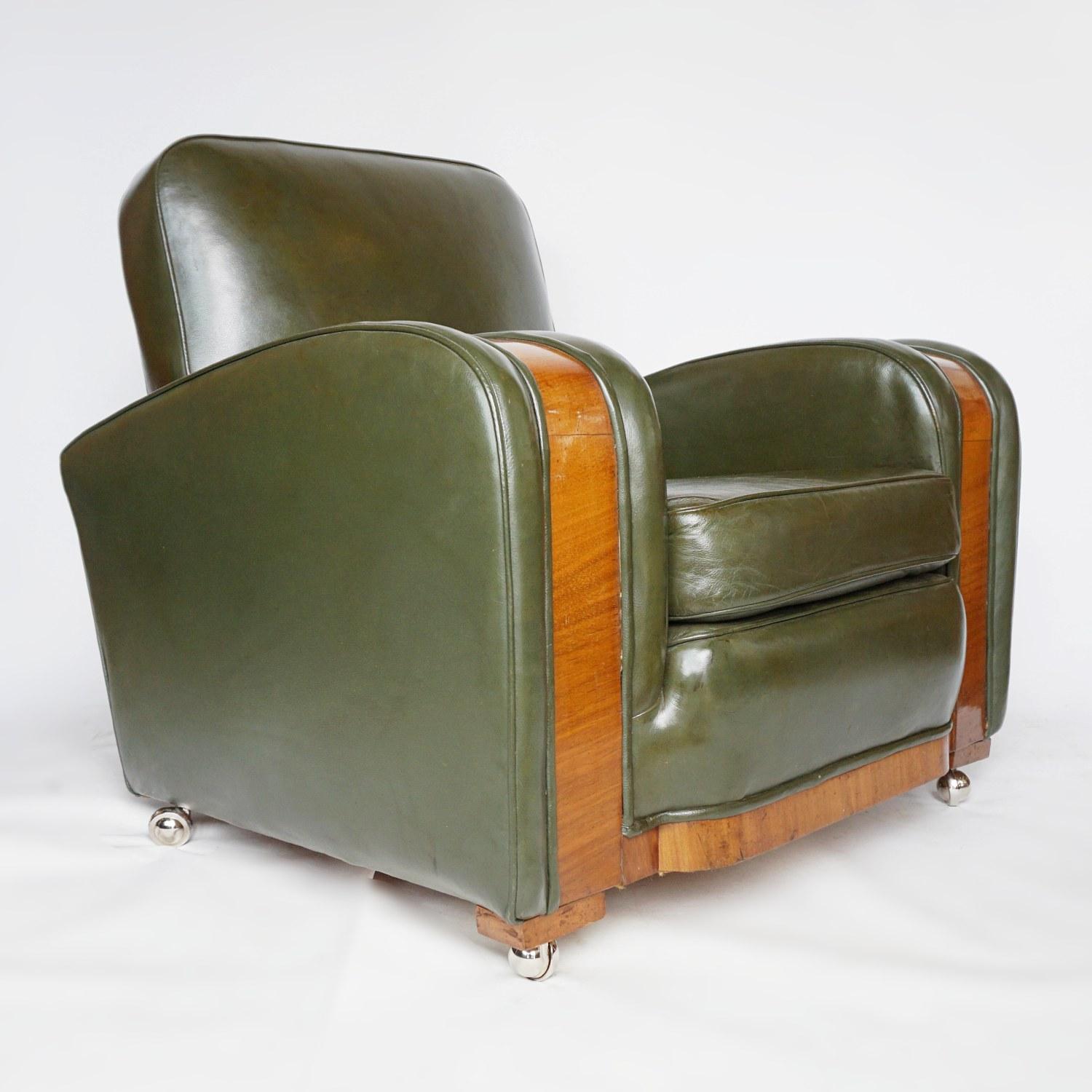 A pair of Art Deco tank chairs attributed to Heal's of London. Figured walnut veneered banding. Upholster in the original dark green leather. Set on new casters. Small bruising to the leather of one of the chairs, photographed. 

Dimensions: H