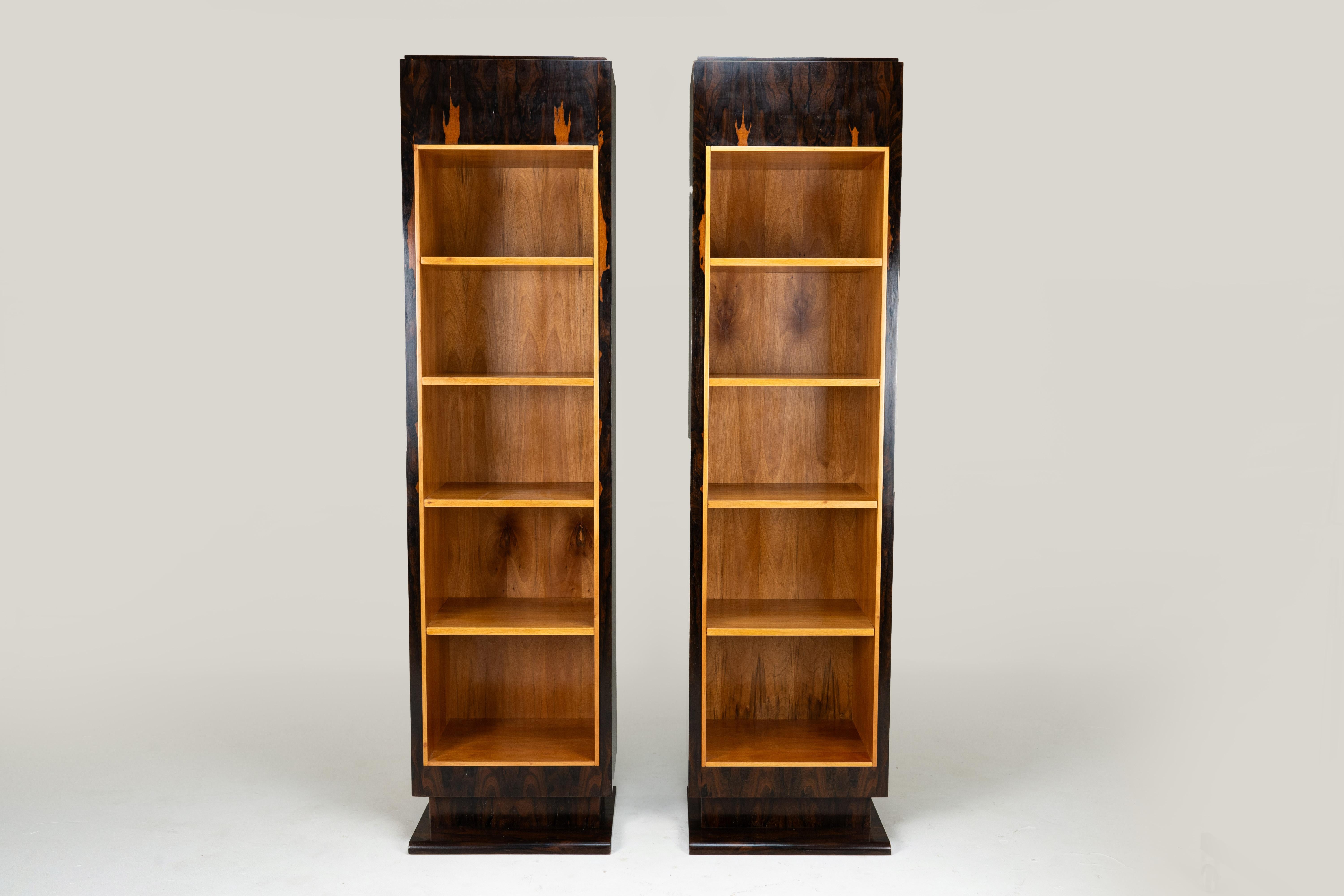 This extraordinary pair of display shelves exudes 1940's Deco elegance and refinement. They are square and austere, except for the quietly curved plinths at their bases.  The exterior casework is palisander, an exotic type of rosewood, mostly found