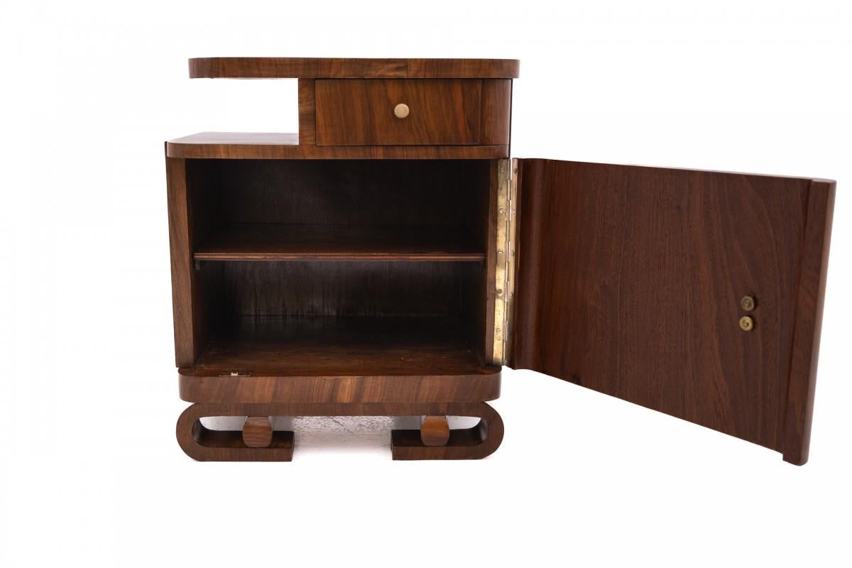 20th Century A pair of Art Deco walnut bedside tables.
