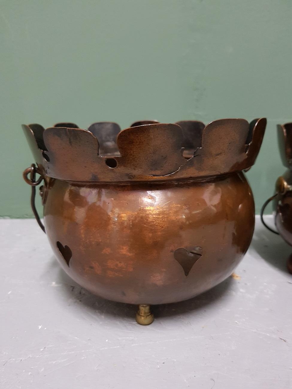 A pair of Art Nouveau copper tea lights decorated with carved hearts and standing on brass and wooden feet, early 20th century. Now they are nice to use as planters.

The measurements are.
Depth 17.5 cm/ 6.8 inch.
Width 17.5 cm/ 6.8