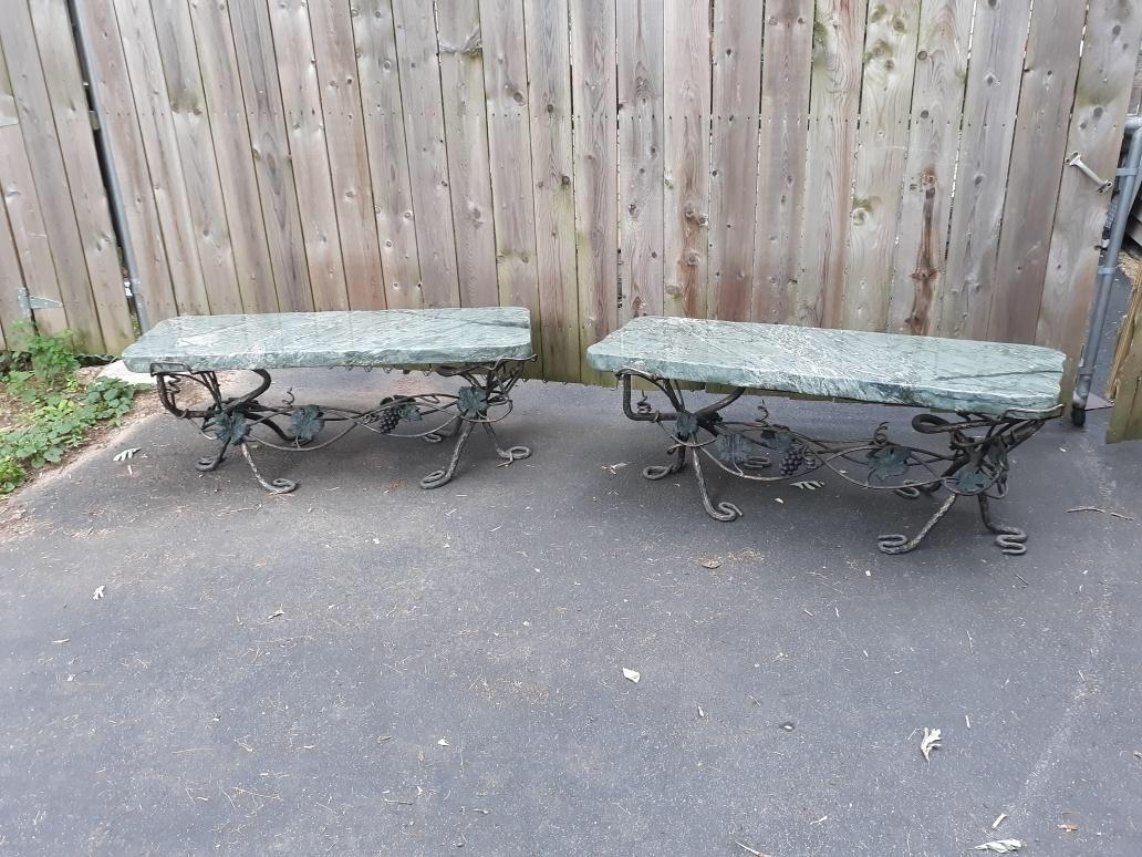 Pair of mid-20th century cold painted iron and marble garden benches. The wrought iron bases with hand forged wine and grape decoration with a weathered finish. The 2