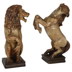 Un par de figuras de cerámica artística esculpidas a mano de un león heráldico y un unicornio.
