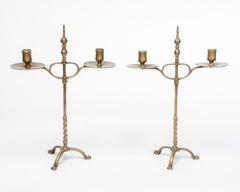 A pair of Arts and Crafts brass twin branch candelabras with adjustable height