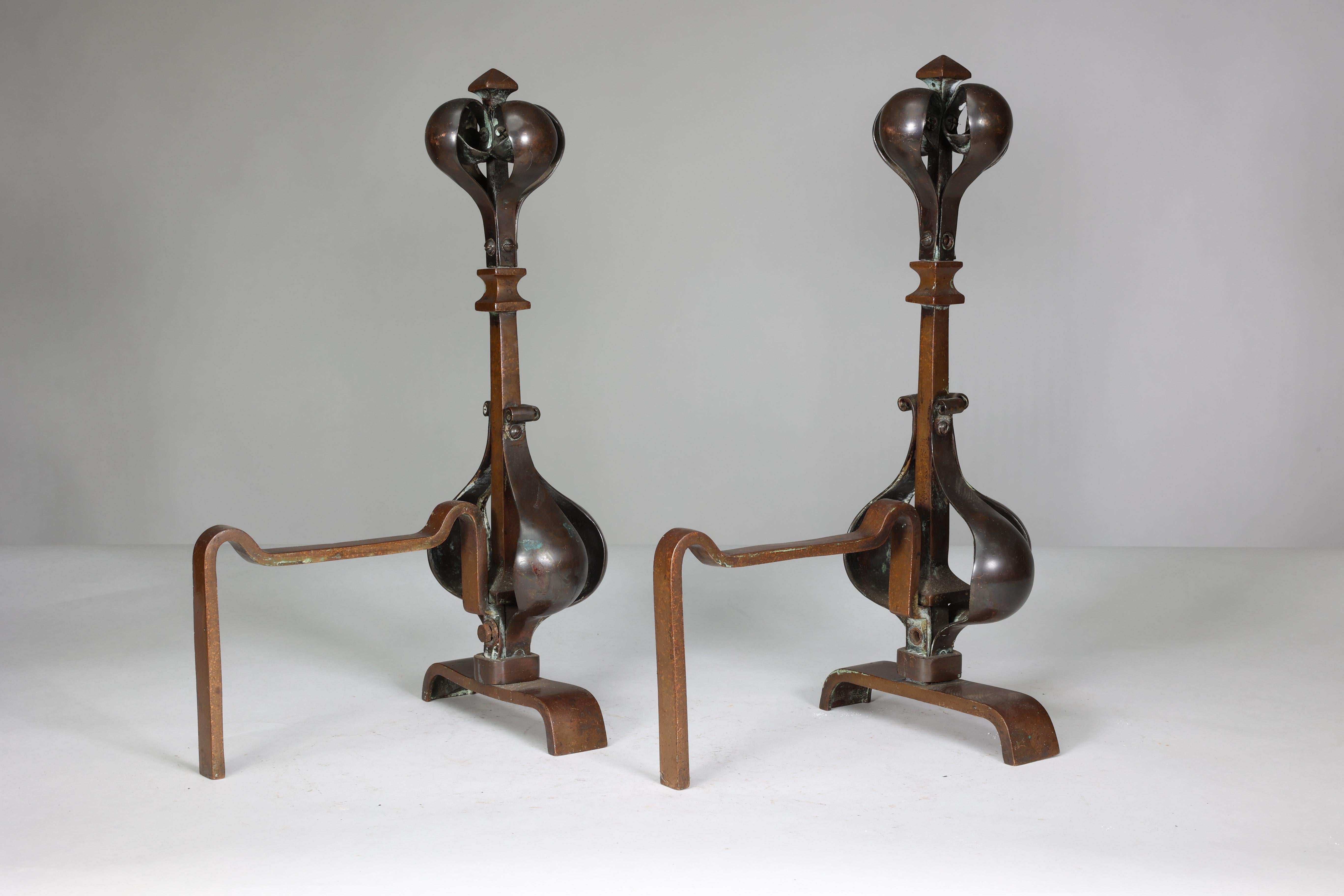 Copper A pair of Arts and Crafts copper and bronze fire dogs with pyramid style finials For Sale
