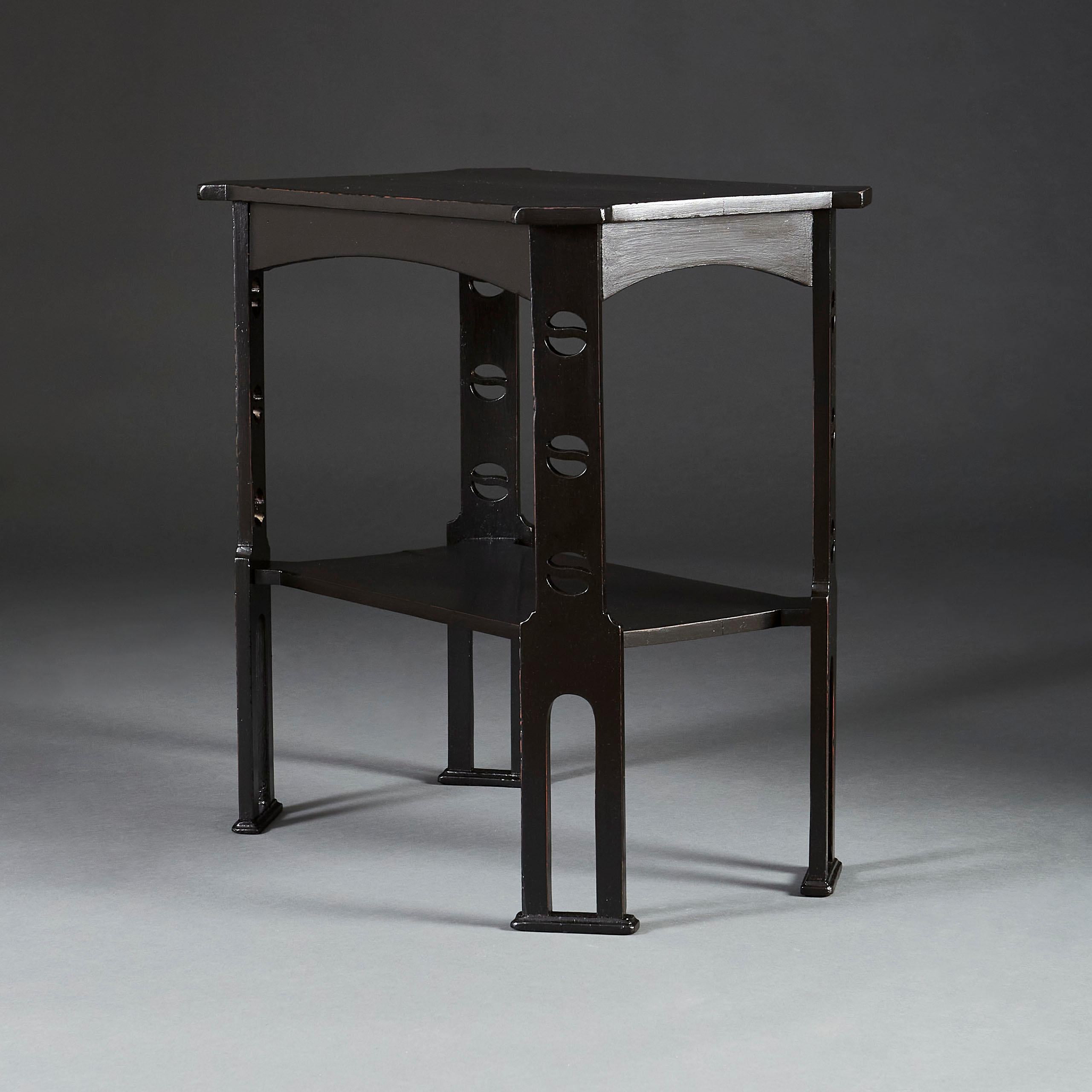 An unusual pair of two tier ebonised wooden rectangular occasional tables with canted corners, pierced upright sections, all supported on plinth feet.