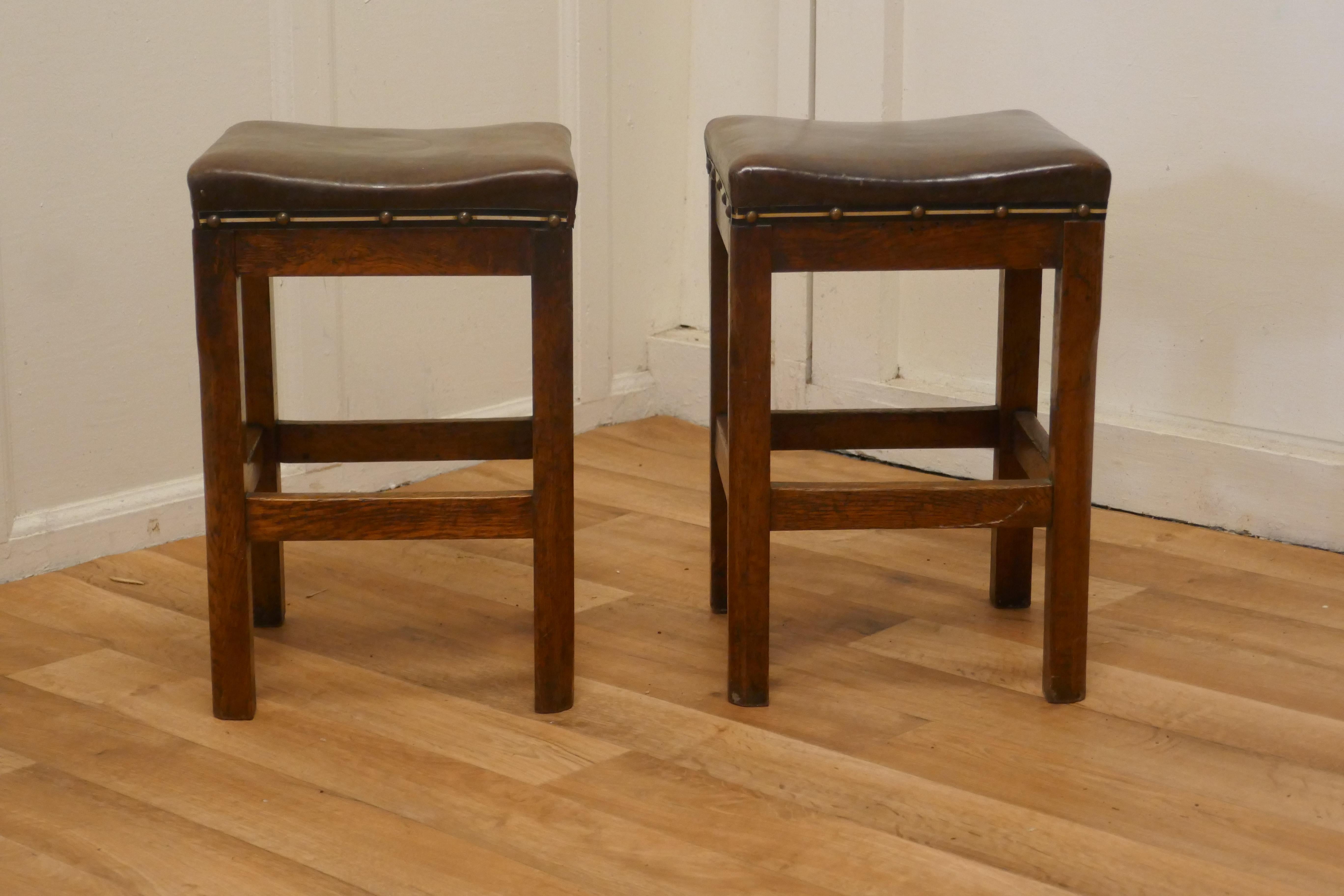 A pair of arts and crafts golden oak and leather stools

These are a very attractive pair they have a square seat and are set on sturdy stretchered legs 
The stools are in good sound condition, and have a pleasantly aged patina
 The stools are