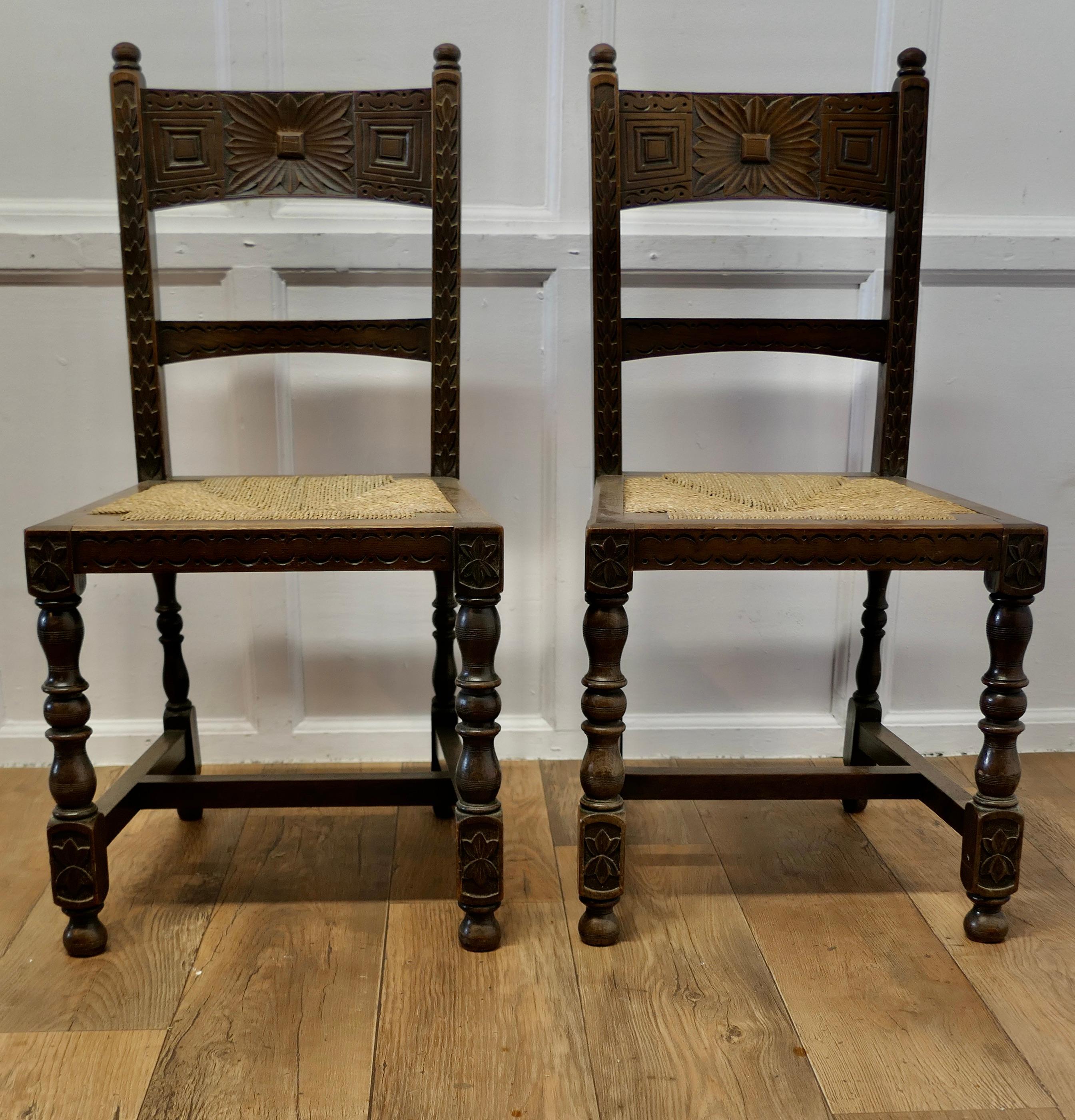 A Pair of Arts and Crafts Gothic Carved Oak Hall Chairs

This is a good quality and attractively carved pair of Chairs, the Chairs have heavily turned legs and the backs are carved in the Gothic style 
The chairs are in good condition and have woven