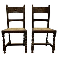 A Pair of Arts and Crafts Gothic Carved Oak Hall Chairs  