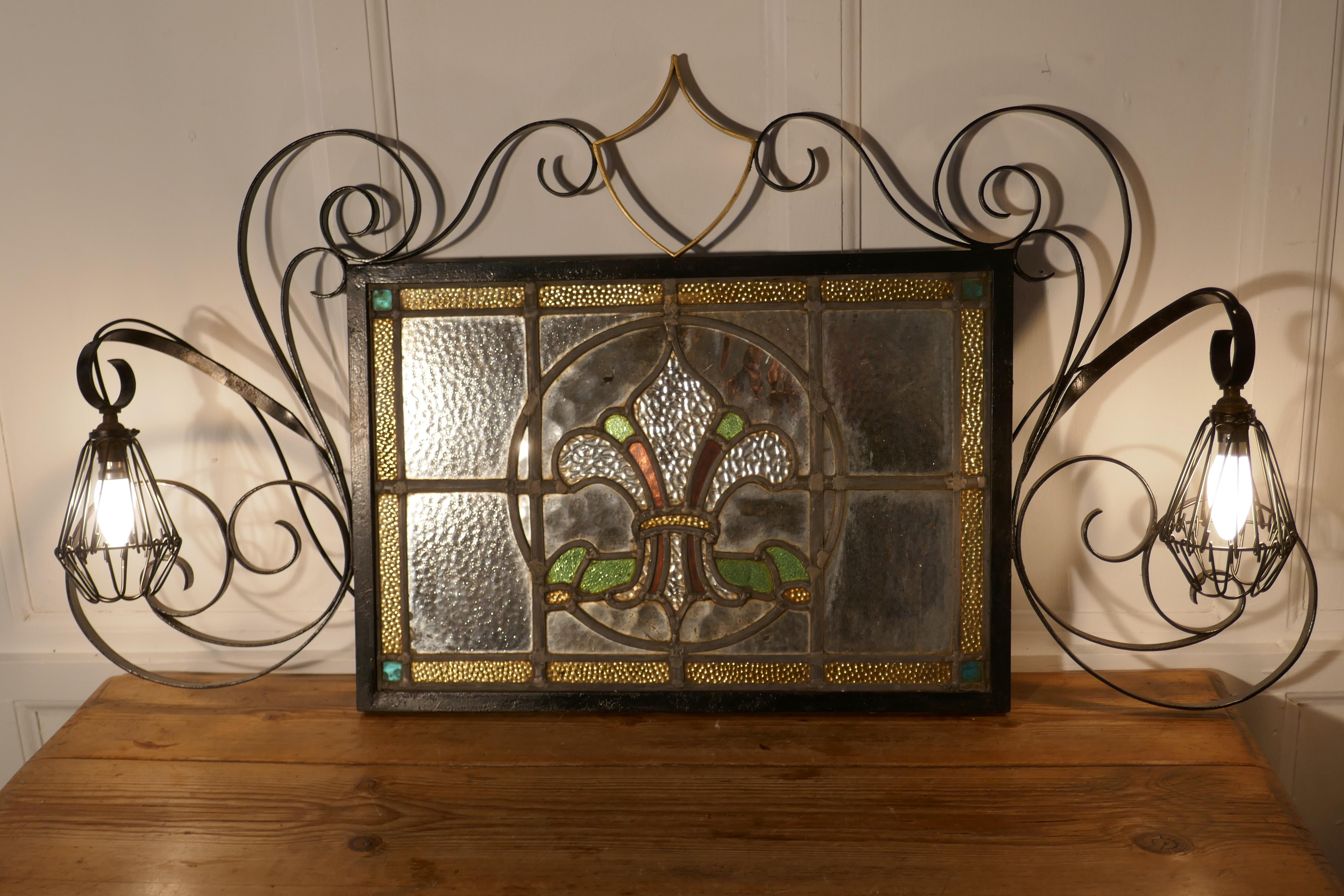 A pair of Arts & Crafts Gothic stained glass mirror lights


A very unusual pair of wrought iron wall hung mirrors with twin light fittings
One stained glass mirror is in the image of a Fleur-de-lis the other of a knight wearing a helmet
The