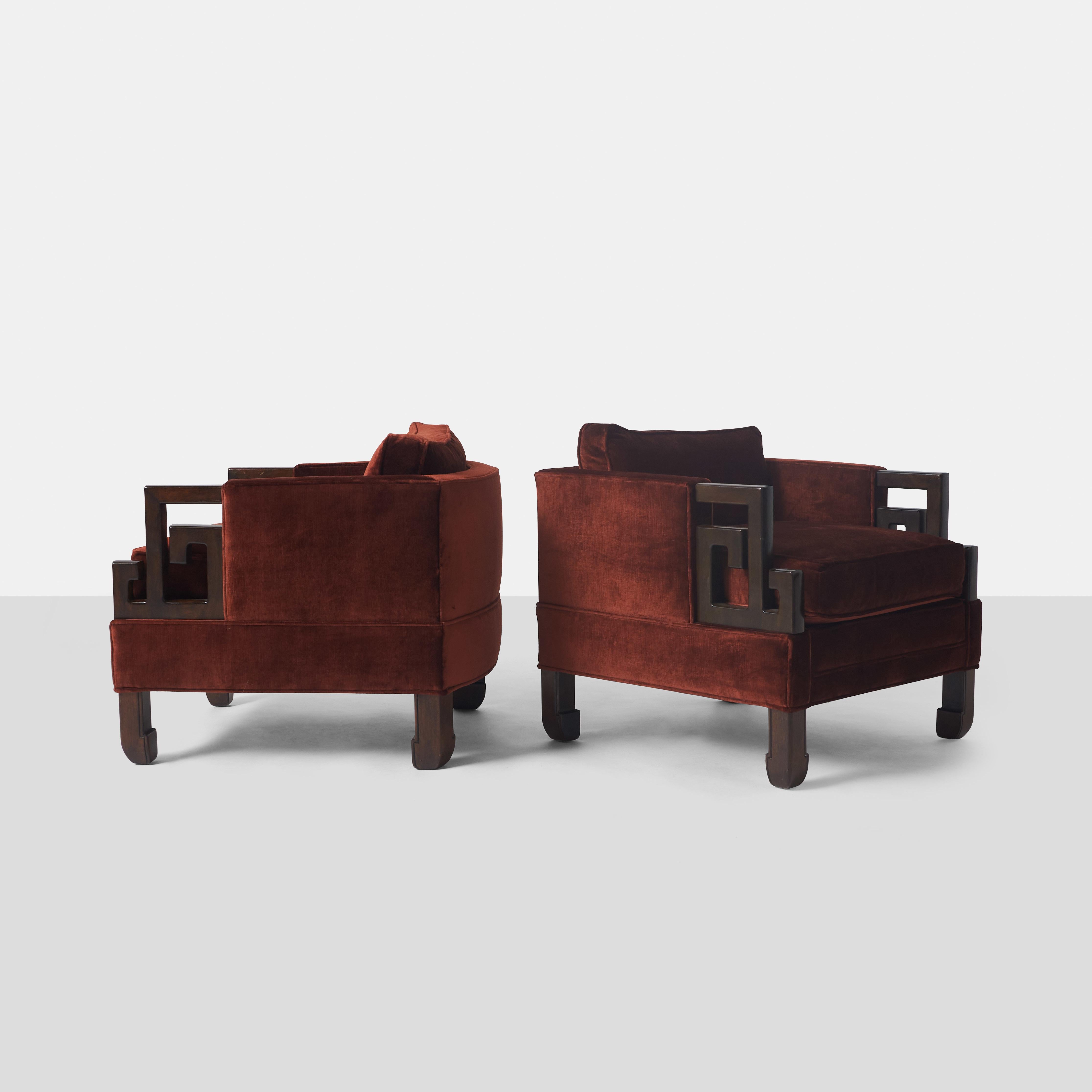 A pair of lounge chairs for luxury furniture store B. Altman & Co. of New York. Attributed to James Mont, the chairs have Asian inspired carved wood arm rests and are covered in a deep red/brown velvet. Retains the retailers label.