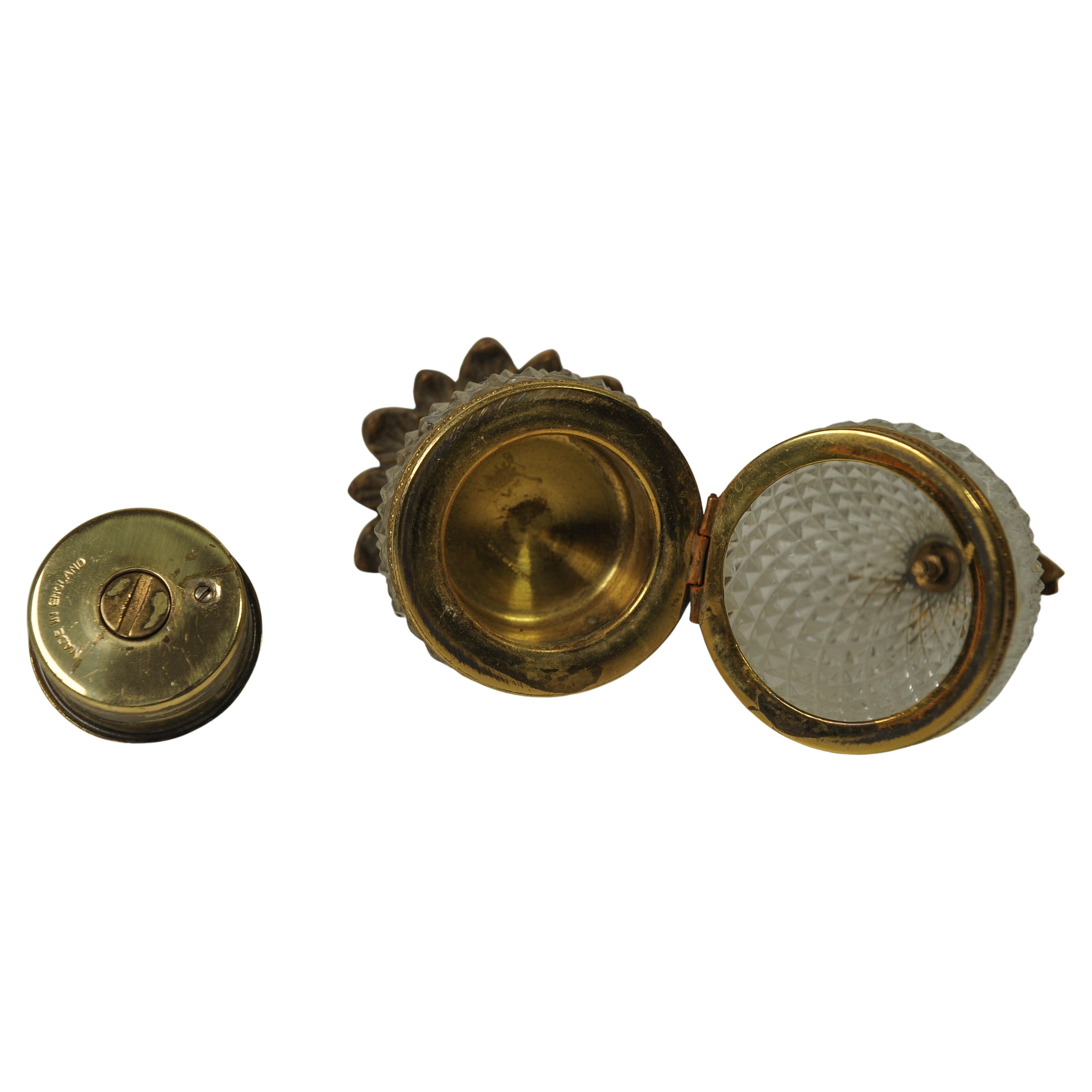 Paire de briquets de table Baccarat en forme d'ananas en verre taillé au diamant et en laiton doré, fabriqués en France.

Les deux briquets sont munis d'une charnière centrale et d'une base à feuilles stylisées montée, décorée d'une couronne de