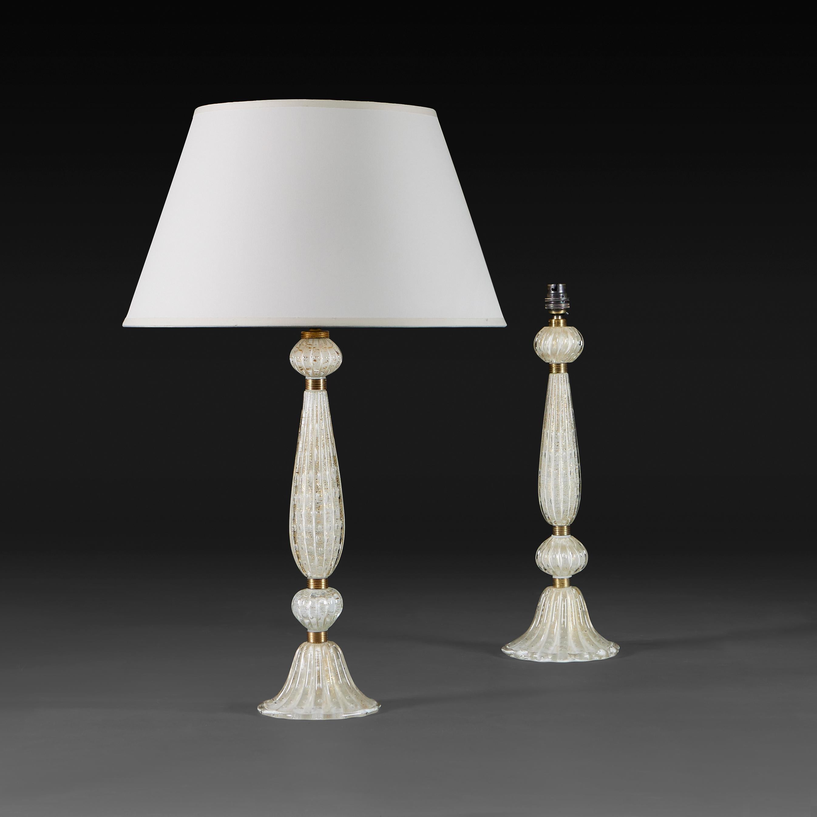 Italy, circa 1950

A pair of Barovier & Toso Murano glass fluted baluster lamps, blown in segments with bullicante bubbles and gold inclusions, fastened with brass bands. 

Height 42.00cm
Diameter of base 14.00cm

Currently wired for the UK with