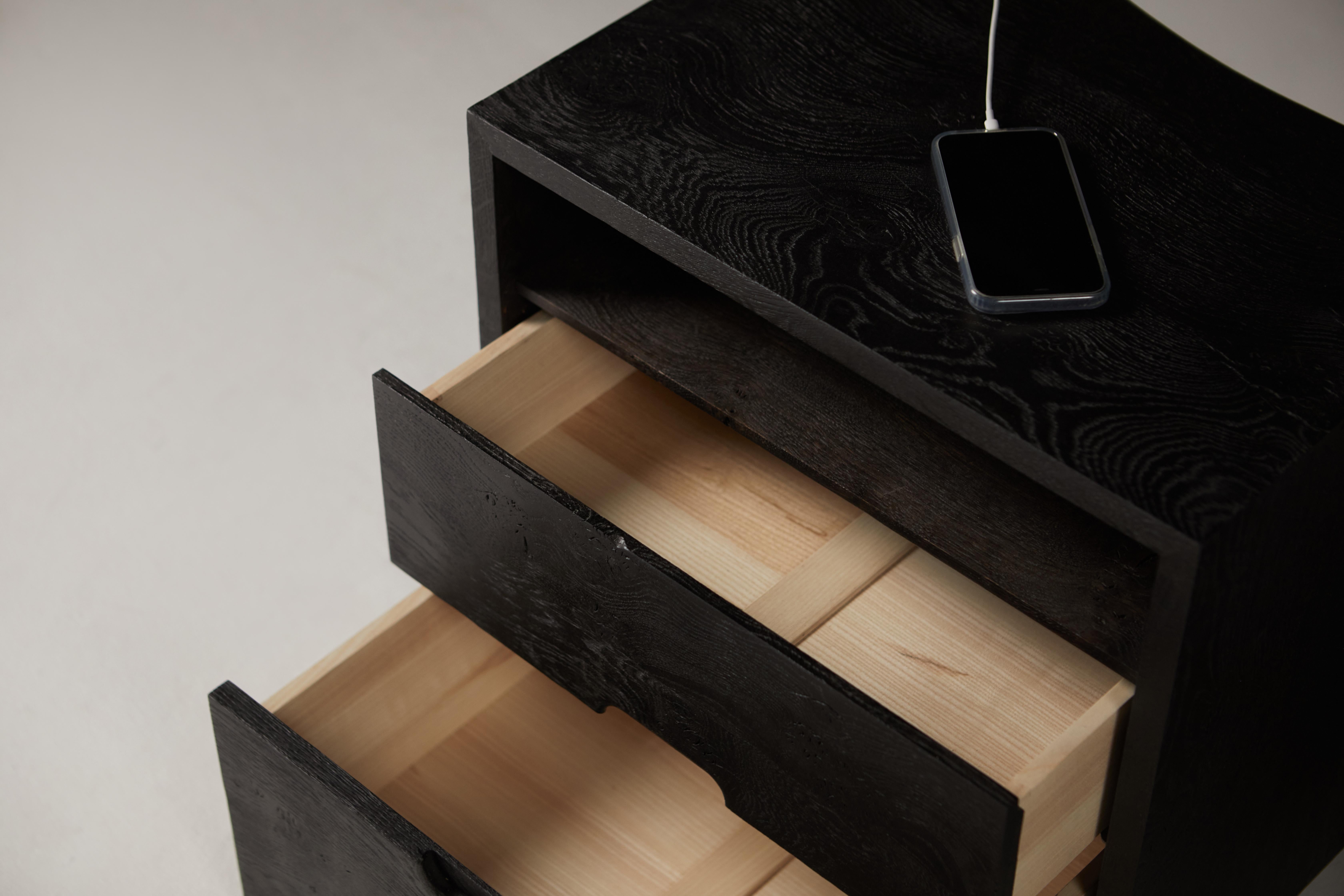 A pair of ebonized Bedside Tables in Solid English Oak.
The two drawer boxes are made in solid ash and run on fully extendable soft close runners. 
The external surfaces have been brushed to give texture, then ebonized and finished with a hard wax