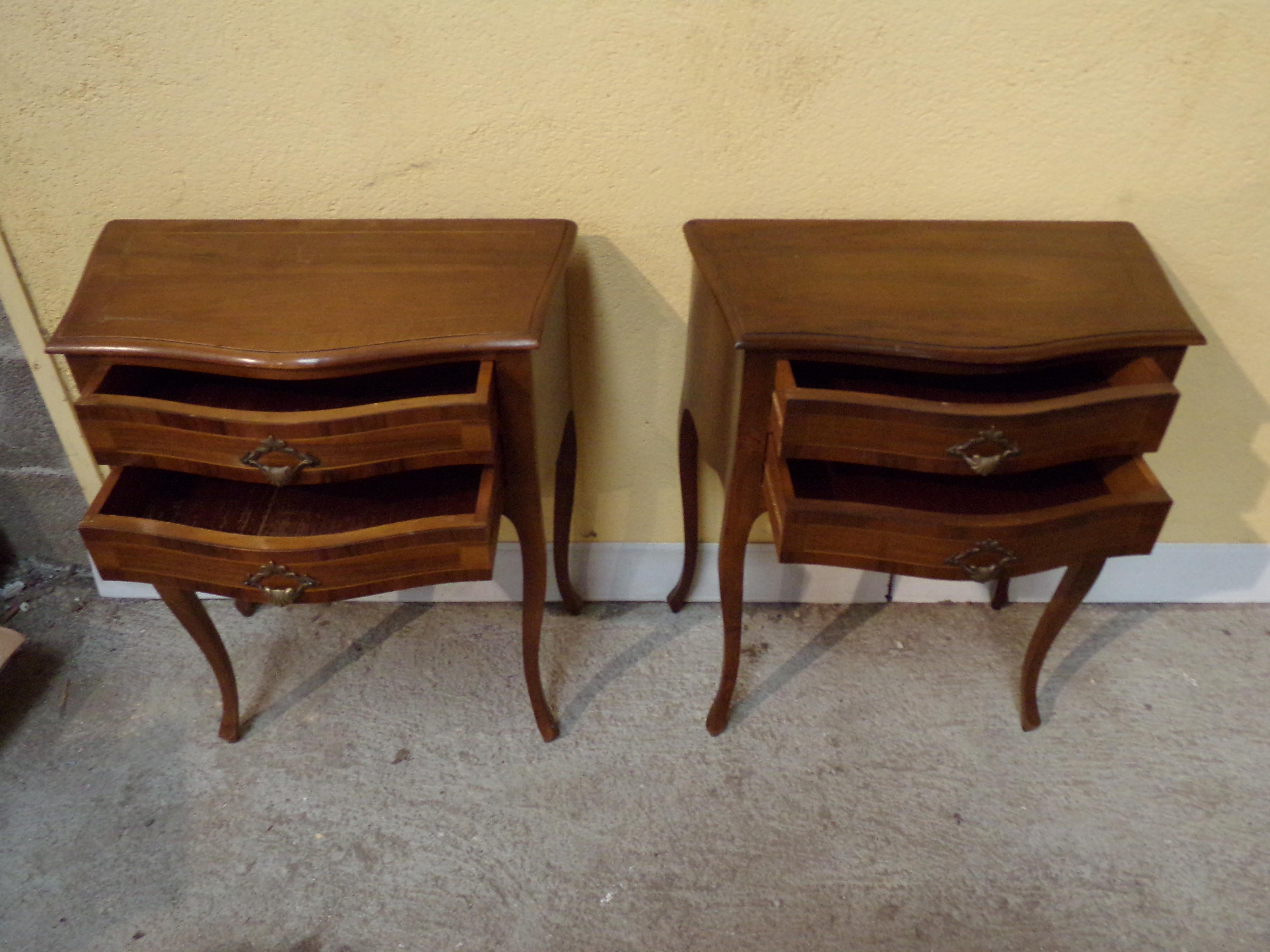 An attractive pair of Louis XV Walnut bedside cabinets with two drawers in each, having gilded handles and inlaid boxwood stringing on the tops raised on cabriole legs. Mid last century.