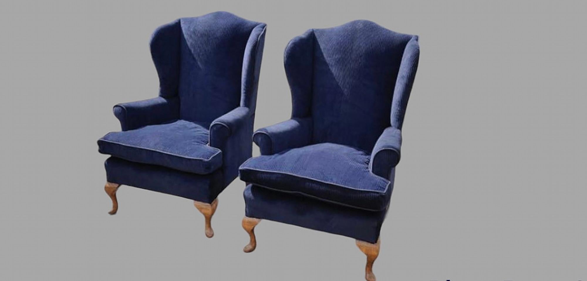 Paire d'attrayants fauteuils à dossier en forme d'ailes, datant de 1950, avec pieds en cabriole, tapissés de velours côtelé marine français et garnis de lin. Hauteur d'assise 50 cm et hauteur d'accoudoir 63 cm.