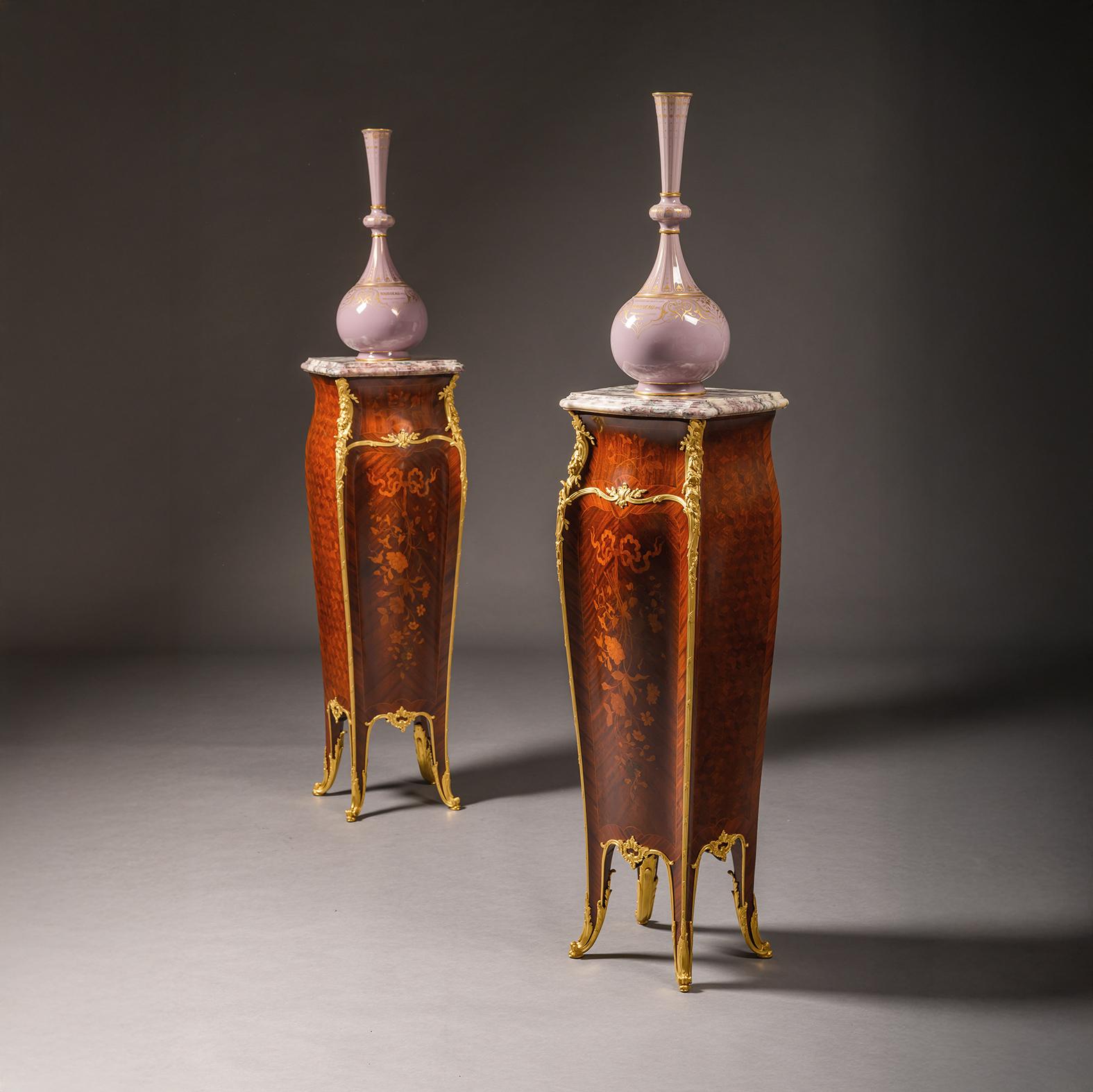 A Pair Of Belle Epoque Gilt-Bronze Mounted Marquetry Pedestals, With Marble Top, By François Linke, Paris.

Each with a shaped Fleur de Pêcher Marble top above a serpentine case fitted with foliate angle mounts and veneered in precious timbers with