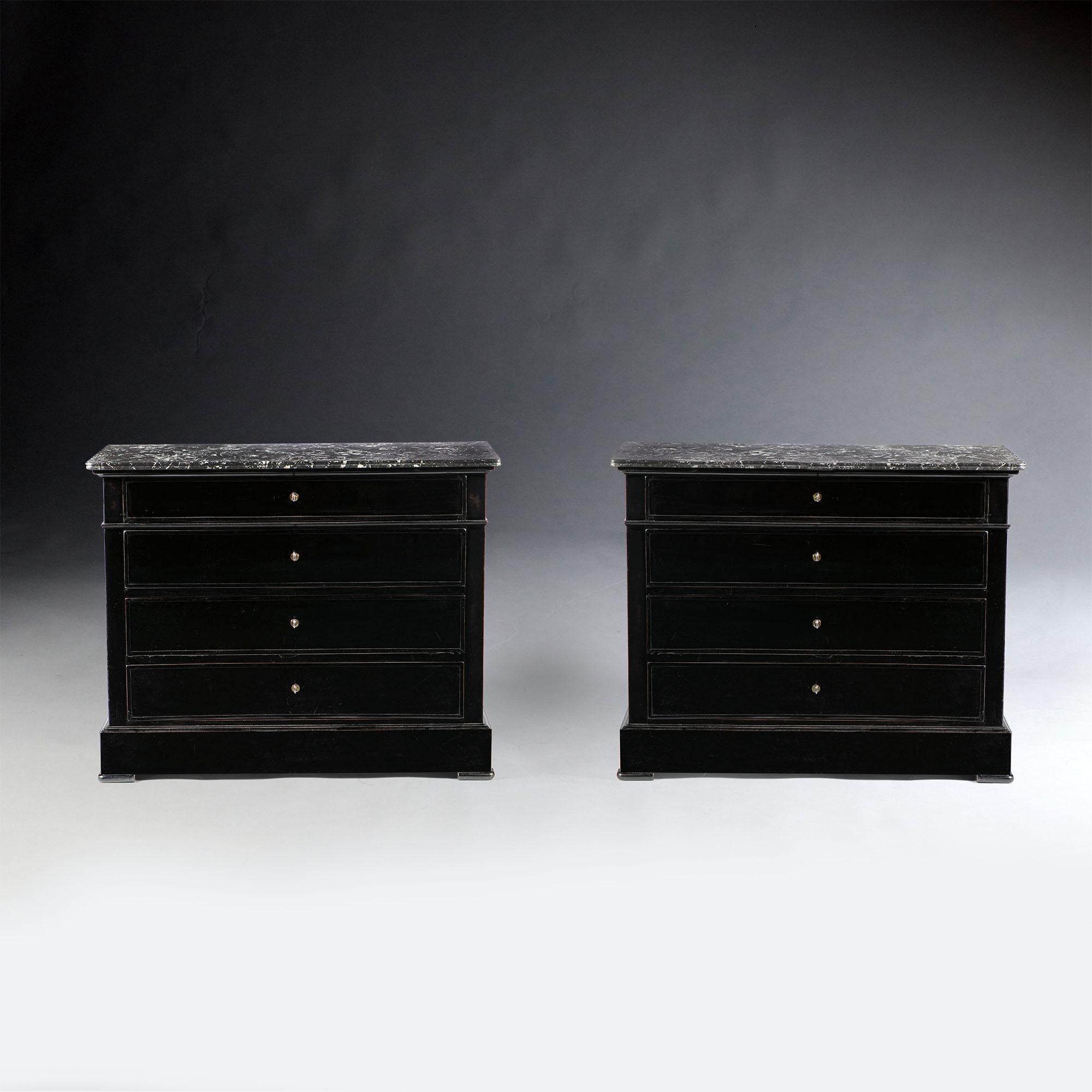 A pair of 19th century ebonized French commodes, each opening with four drawers to the front, with brass escutcheons and keys, with original grey marble tops.
 
  
