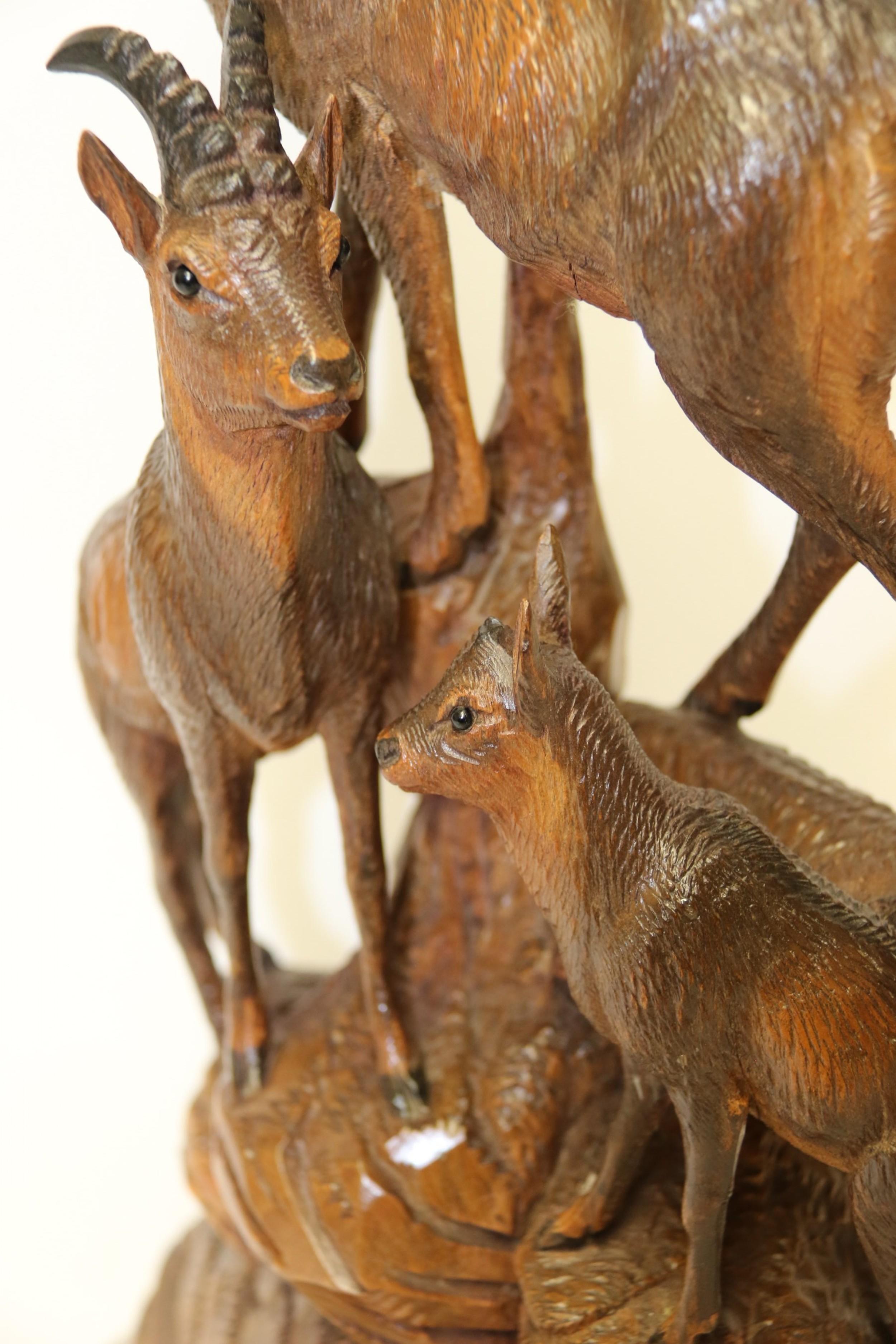 This late 19th century Black Forest pair of finely carved linden wood figure groups depict two family groups of Ibex and Chamois each with a male and female with their young.
They are both standing on a naturalistic rock terrain.

This pair of