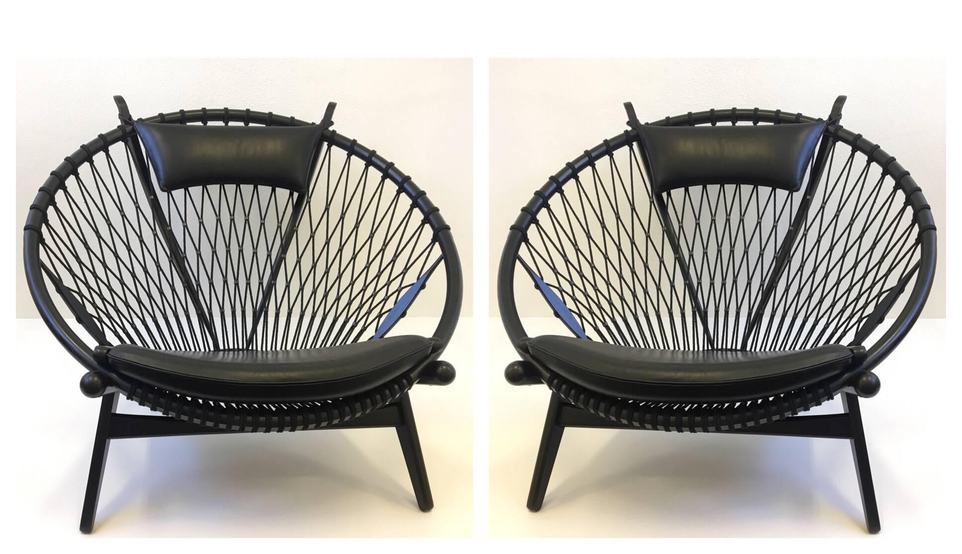 A spectacular pair of PP 130 circle lounge chairs designed by Renowned Danish designer Hans J. Wegner for PP Møbler in the 1980s. This was the last chair designed by Wegner. The chairs are oak lacquered in black, the seats and the headrest are