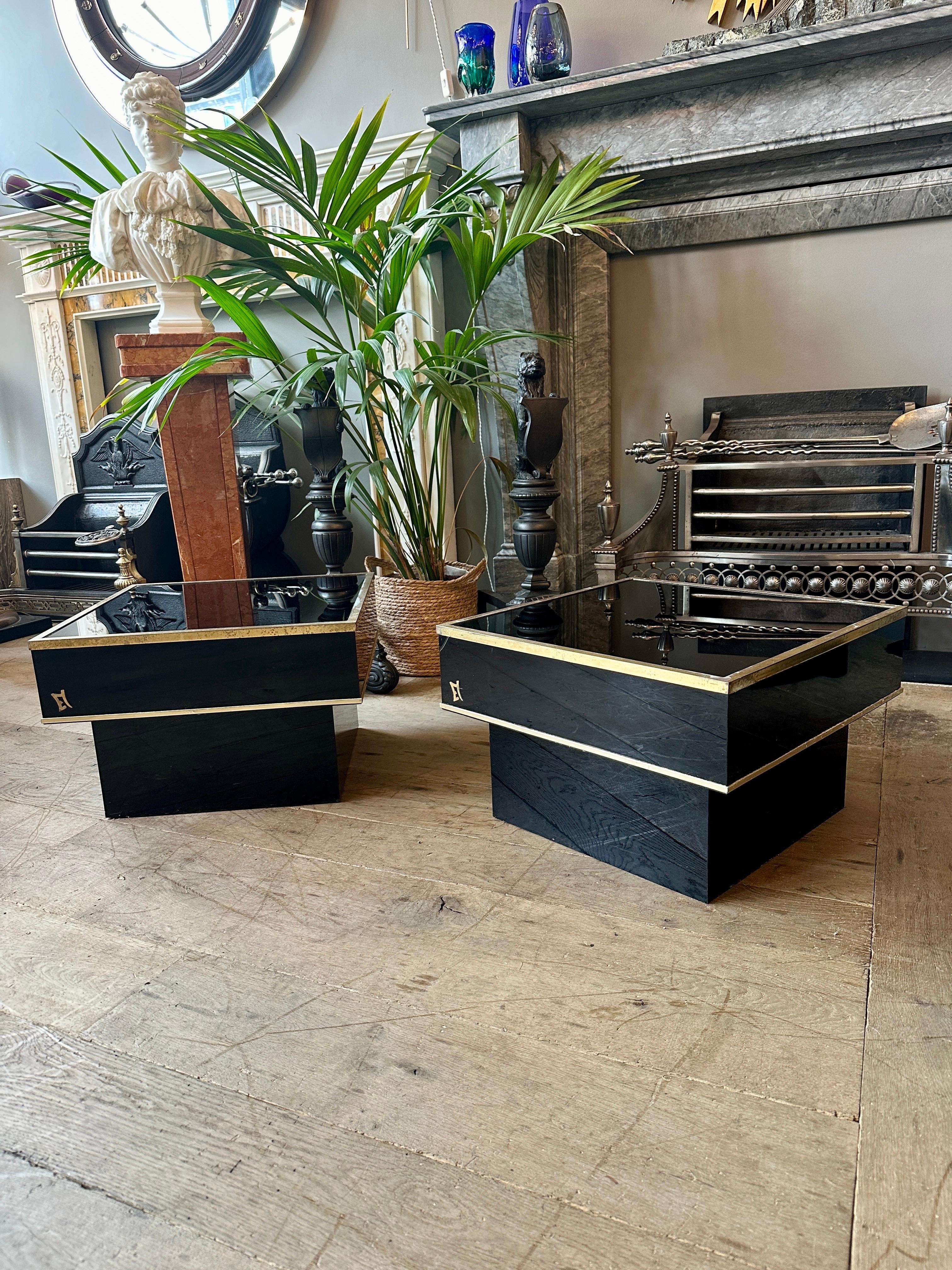 Paire de tables basses ou d'appoint carrées continentales laquées noir et garnies de laiton sur des bases flottantes. La garniture en laiton est patinée, comme le montrent les images, et la marque du fabricant se trouve d'un côté. 

Circa 1970