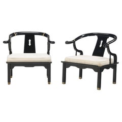 A pair of black lacquered wishbone form chairs in the manner of James Mont