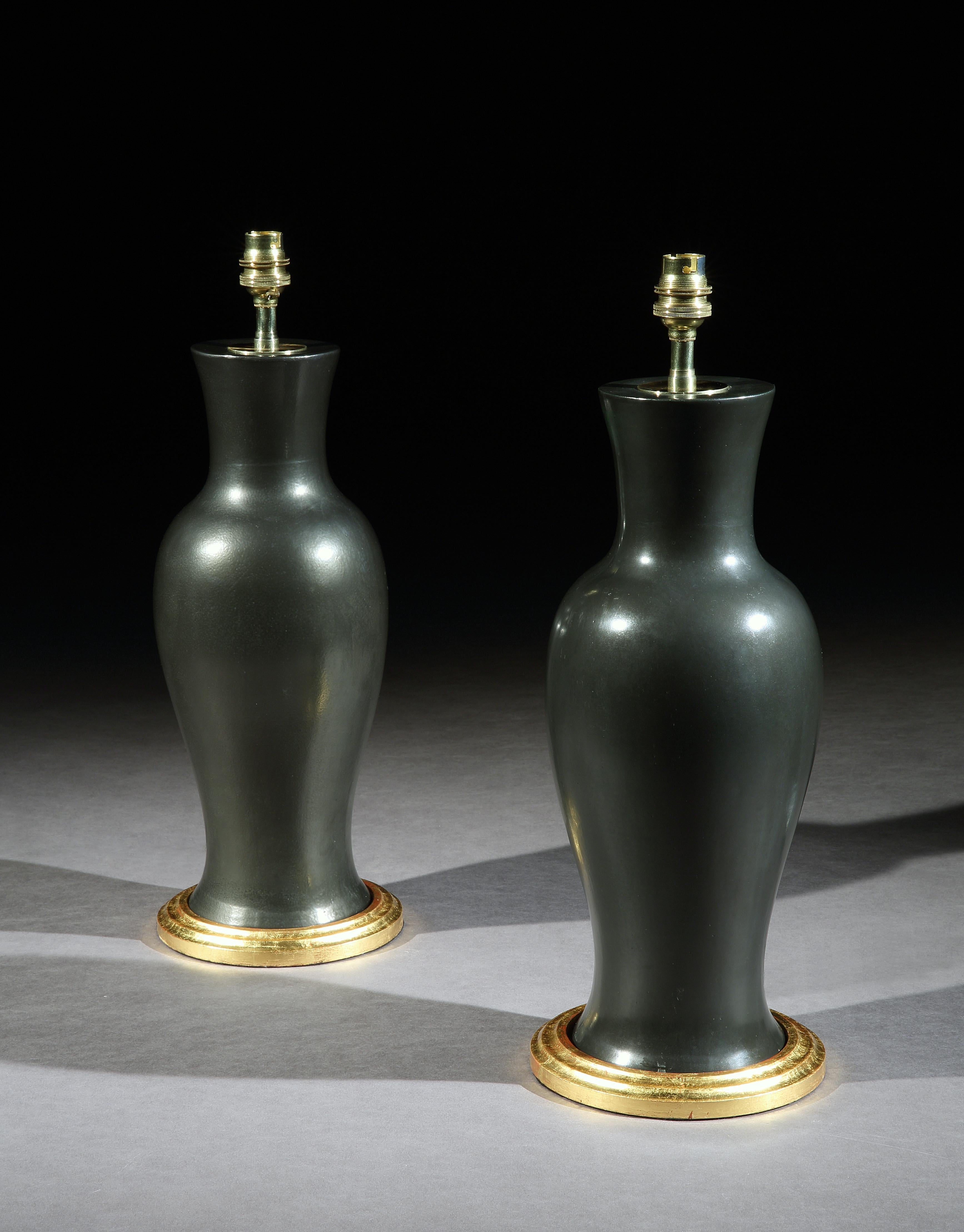 A pair of Chinese black porcelain baluster vases of elegant form. Now mounted as table lamps with hand gilded turned bases.

Measures: Height of vase 16 in (41 cm) including base, excluding electrical fitments and lampshades

These lamps can be
