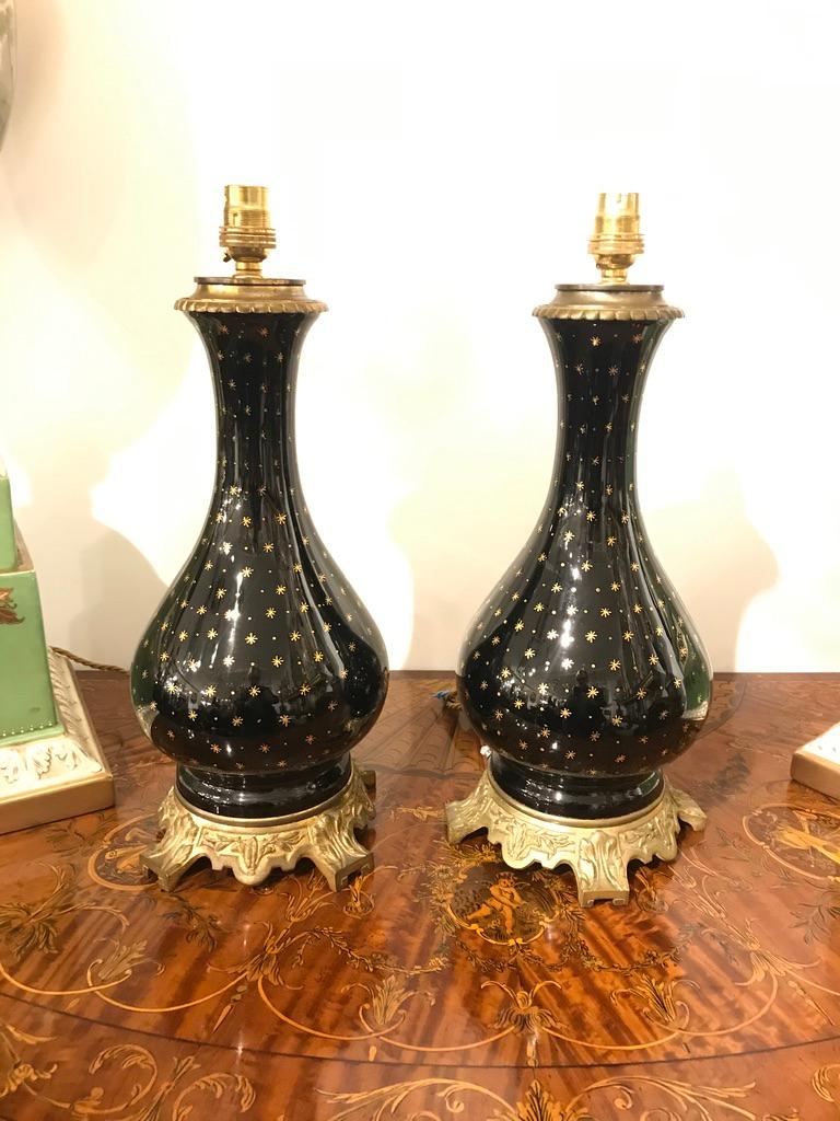 Français Paire de lampes en porcelaine noire sur socle en bronze doré avec détails en forme d'étoiles dorées en vente