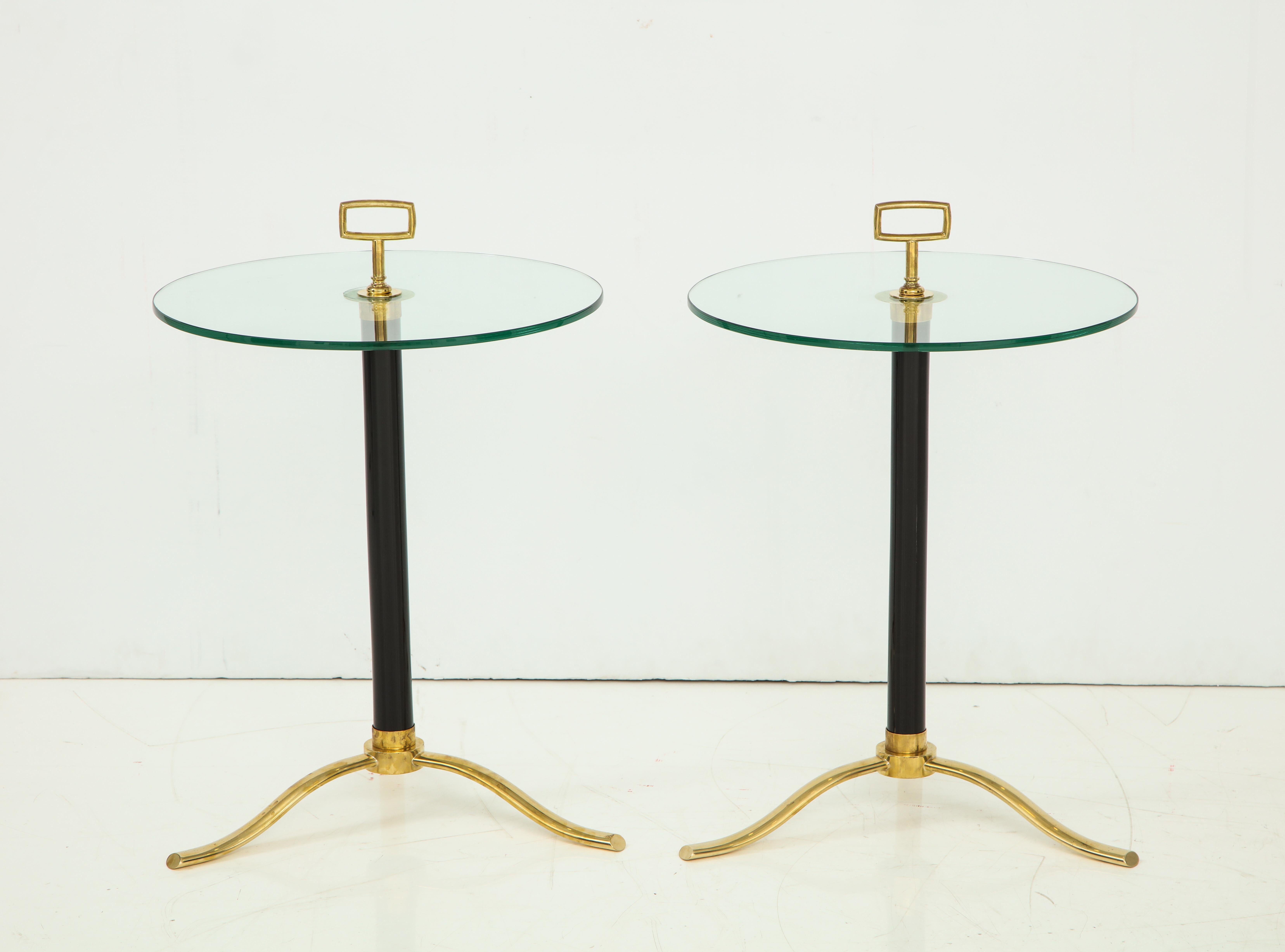 A pair of Italian hand blown Murano side or end tables with circular glass tops surmounted by large rectangular glass finials supported by vintage black glass tubular bases resting on brass tripod feet.