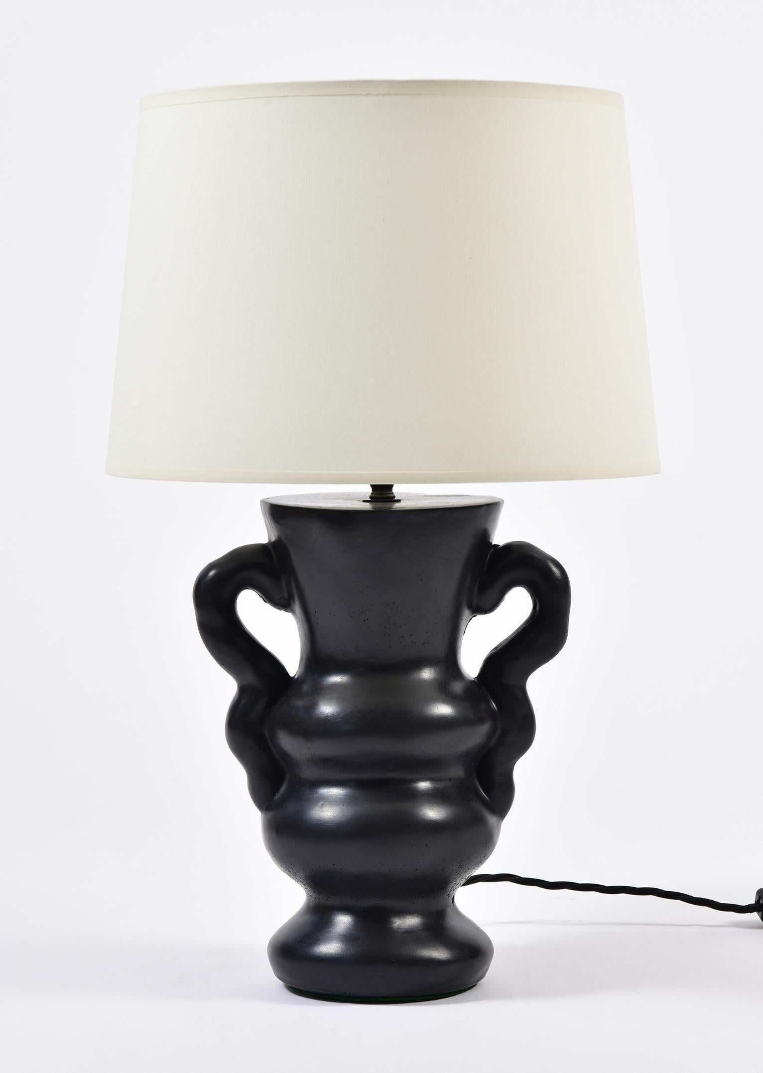 A pair of Ysolde table lamps, by Dorian Caffot de Fawes 
Hand cast in London, black stained in the mass polished and waxed high quality plaster, with a bespoke ivory fabric tapered shade
The shade is included in the stated dimensions.
