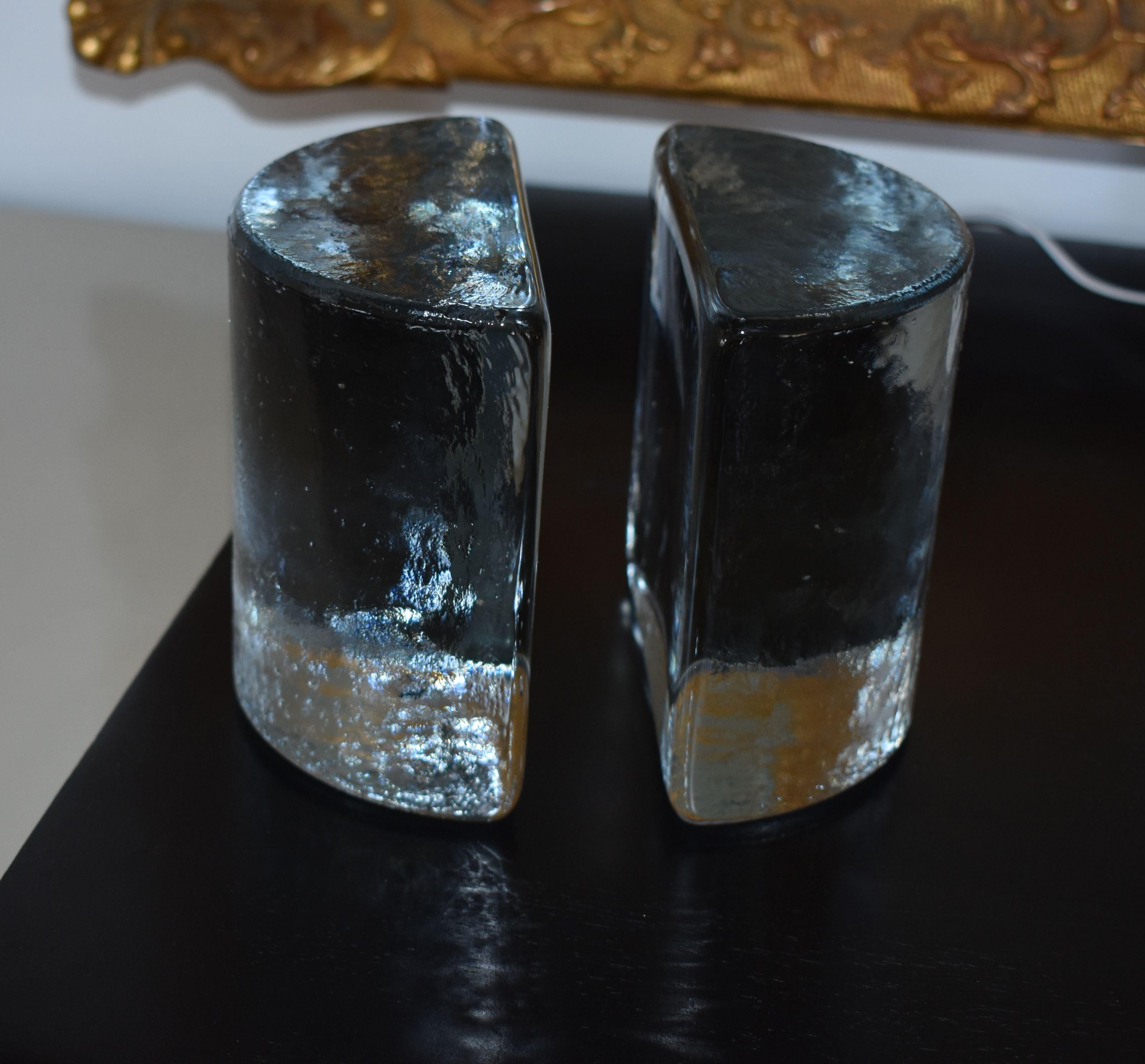Pair of glass handmade bookends made by Blenko. Each one look like a chunky half circle block of ice.

Blenko sticker bookend.