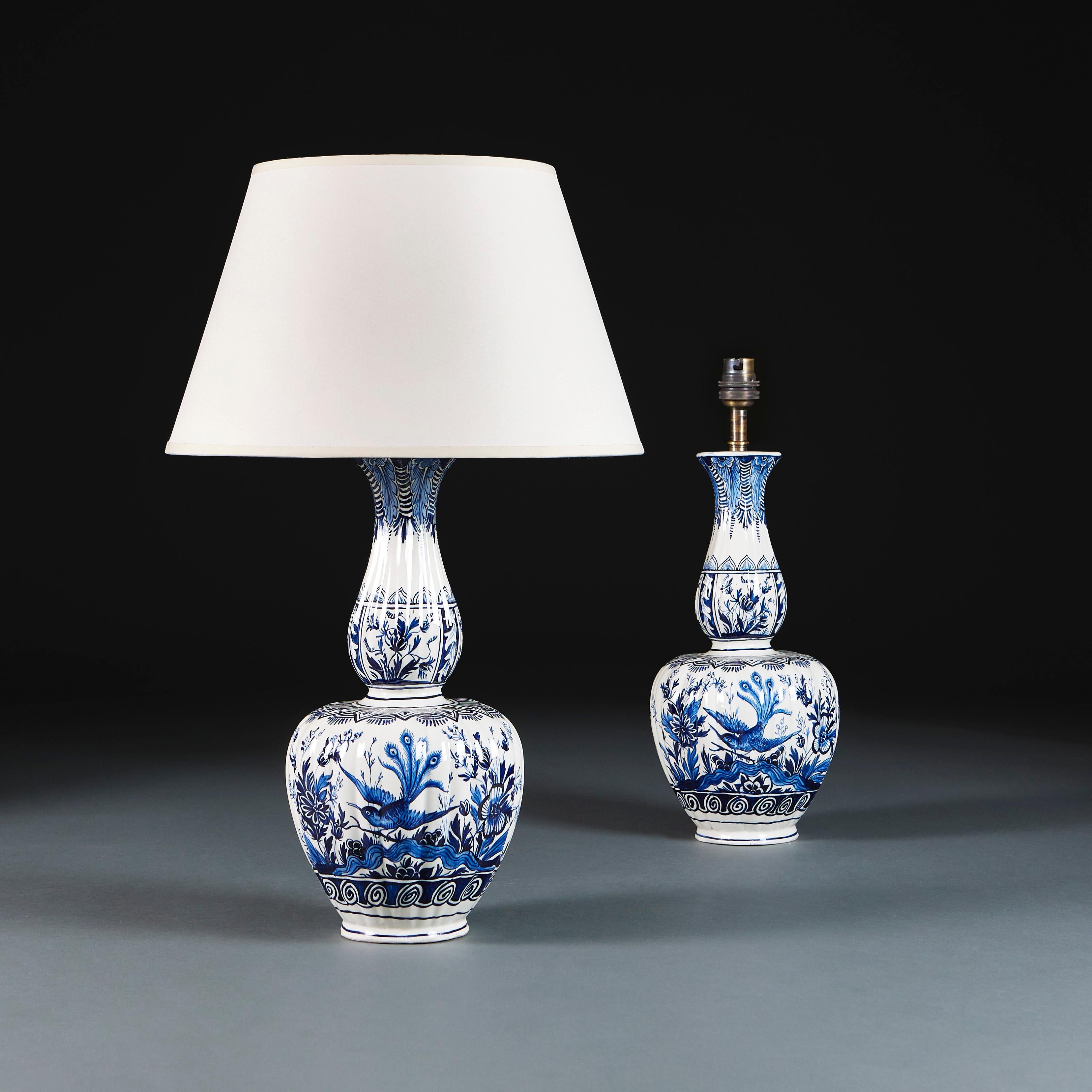 Low Countries, circa 1890

A pair of late nineteenth century blue and white Delft vases, of gadrooned double gourd form, decorated throughout with peacocks, tropical flora and scrolls, now converted as lamps.

Height 42.00cm
Height with shade