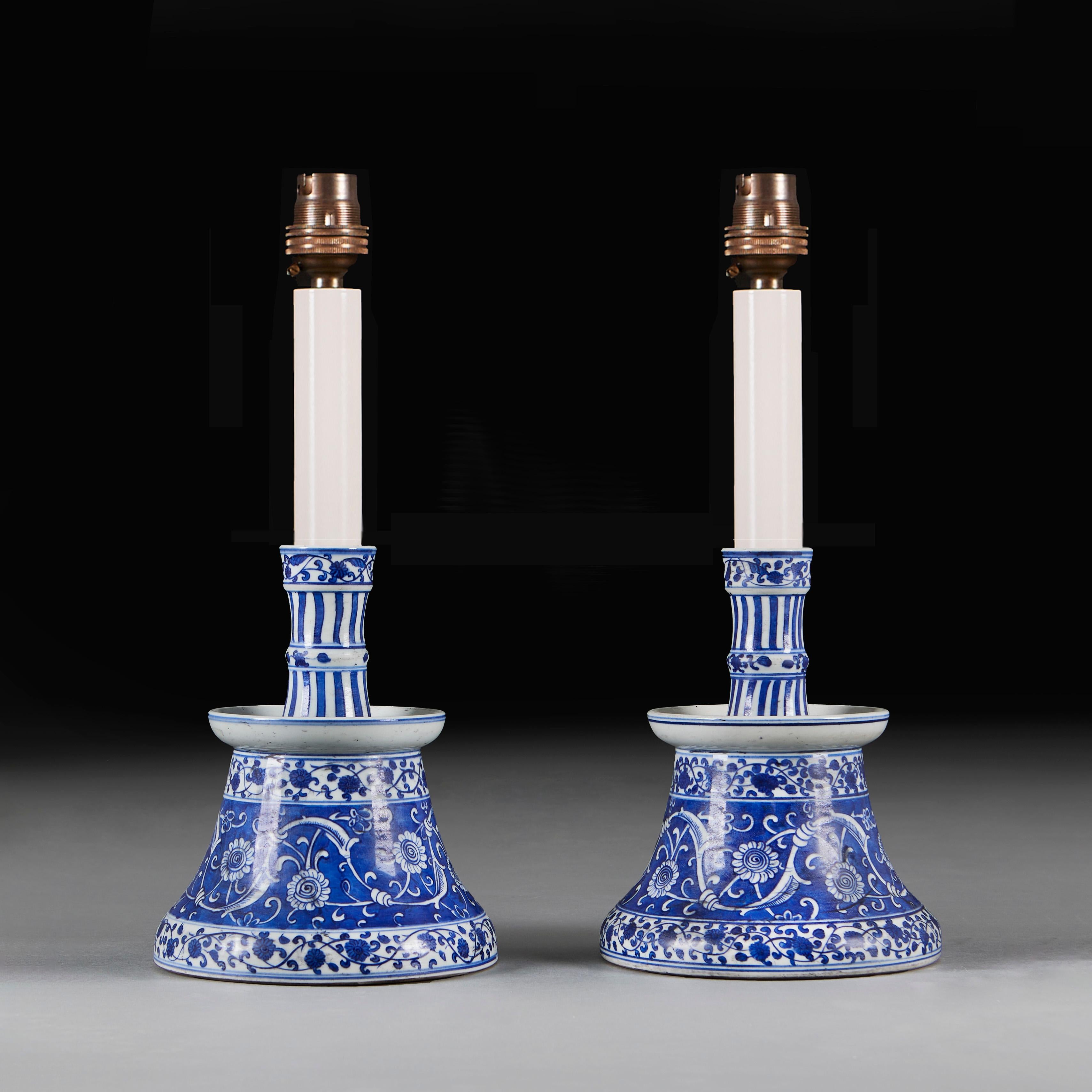 France, circa 1900
A pair of early twentieth century Iznik style candlesticks, with blue and white decoration throughout, showing scrolling chrysanthemums, now wired as lamps.

Height of candlestick   24.00cm
Height with shade    58.00cm
Diameter of