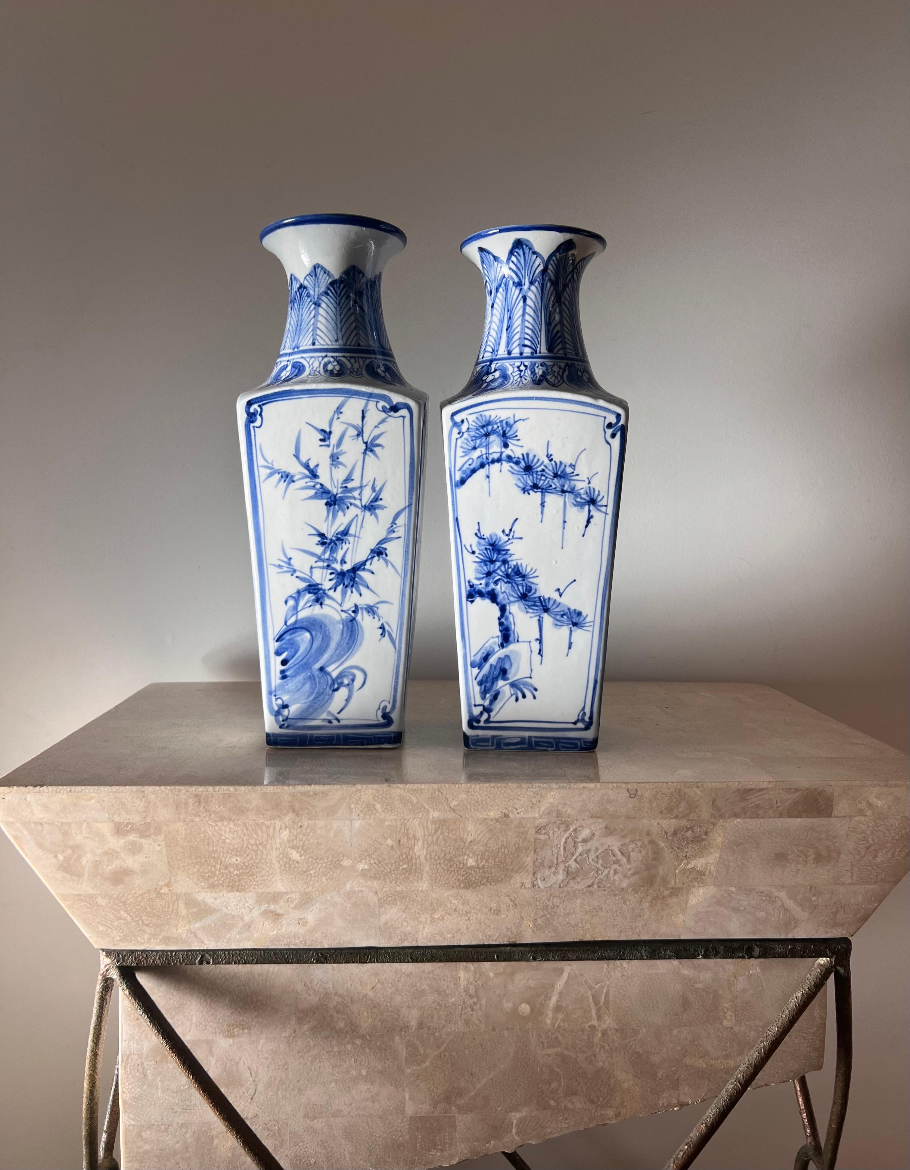 A pair of blue and white porcelain Chinese vases featuring motifs of fir trees, cherry blossoms, and other flora. I am uncertain about the era these are from, possibly late 19th century or early 20th but it could be earlier. They are unsigned and