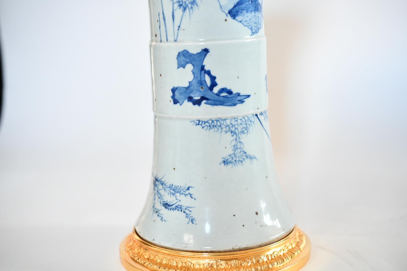 A pair of blue and white porcelain lamps, painted with mountain village scenes, and fine cast gilt brass bases
Each lamp installed two standard sockets
To the top of the porcelain: 14 in/H
lamp shade not included.