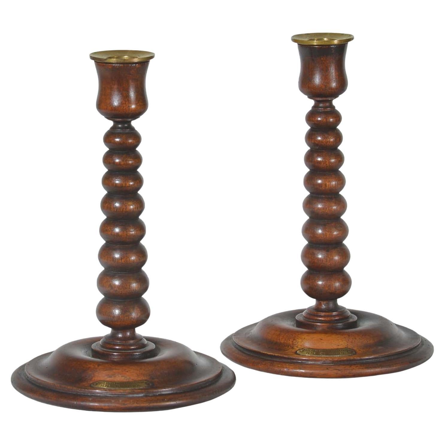 A pair of bobbin turned teak candlesticks - Royal yacht HMS Renown
